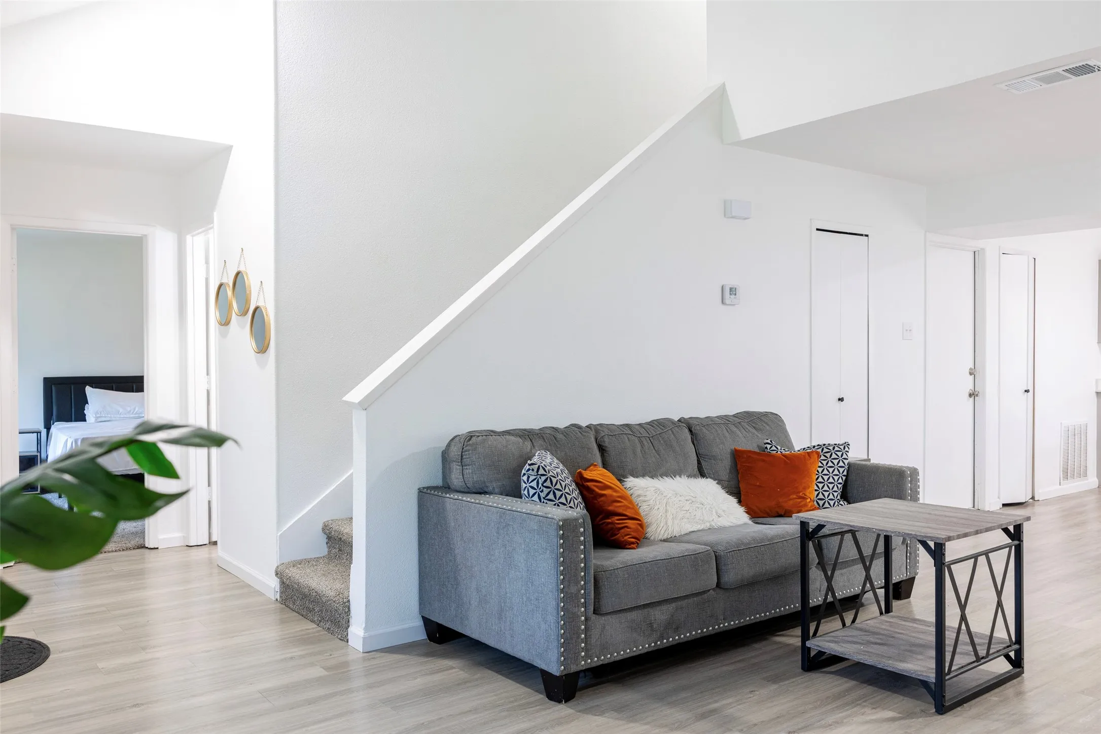 Wood-finish flooring, white walls, and a carpeted staircase