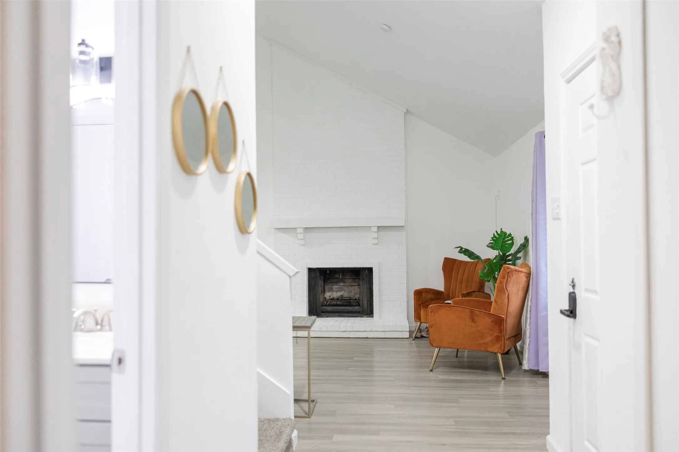 Vaulted ceiling accentuates the painted brick fireplace with a mantel