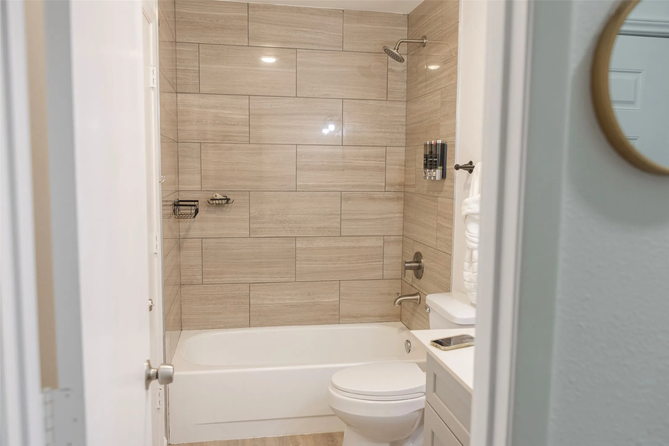 Tiled shower and bath combination with a chrome showerhead and faucet