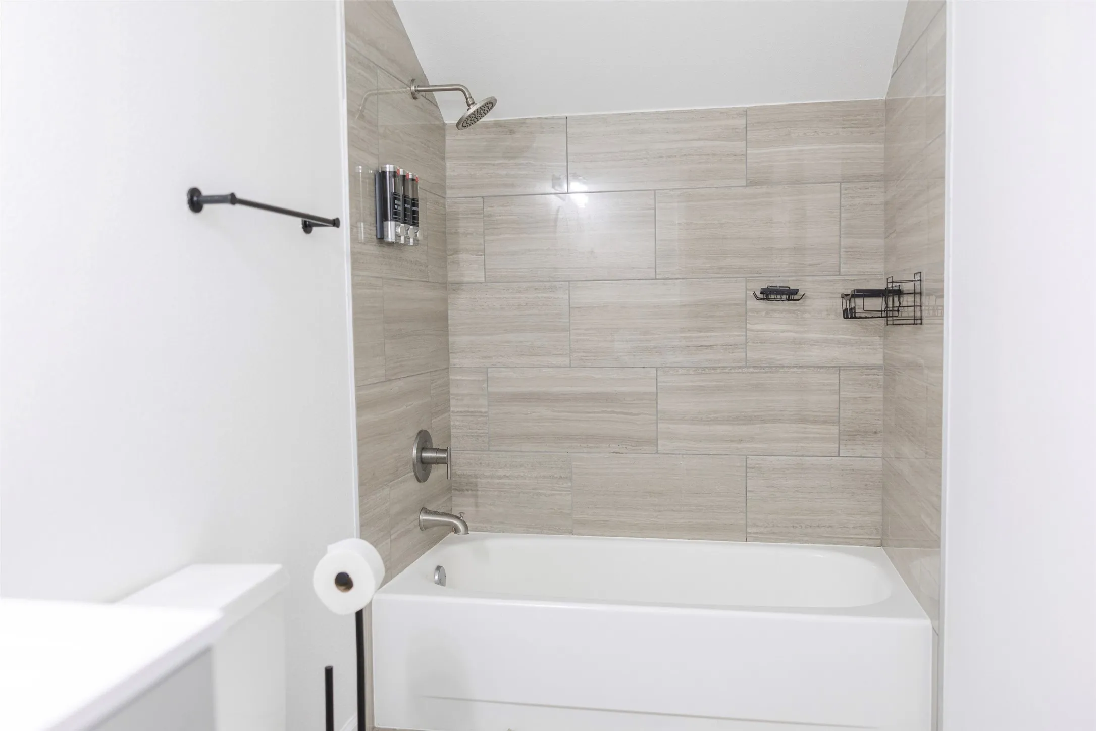 Bathtub with subway tile surround, rainfall showerhead, and brushed nickel fixtures