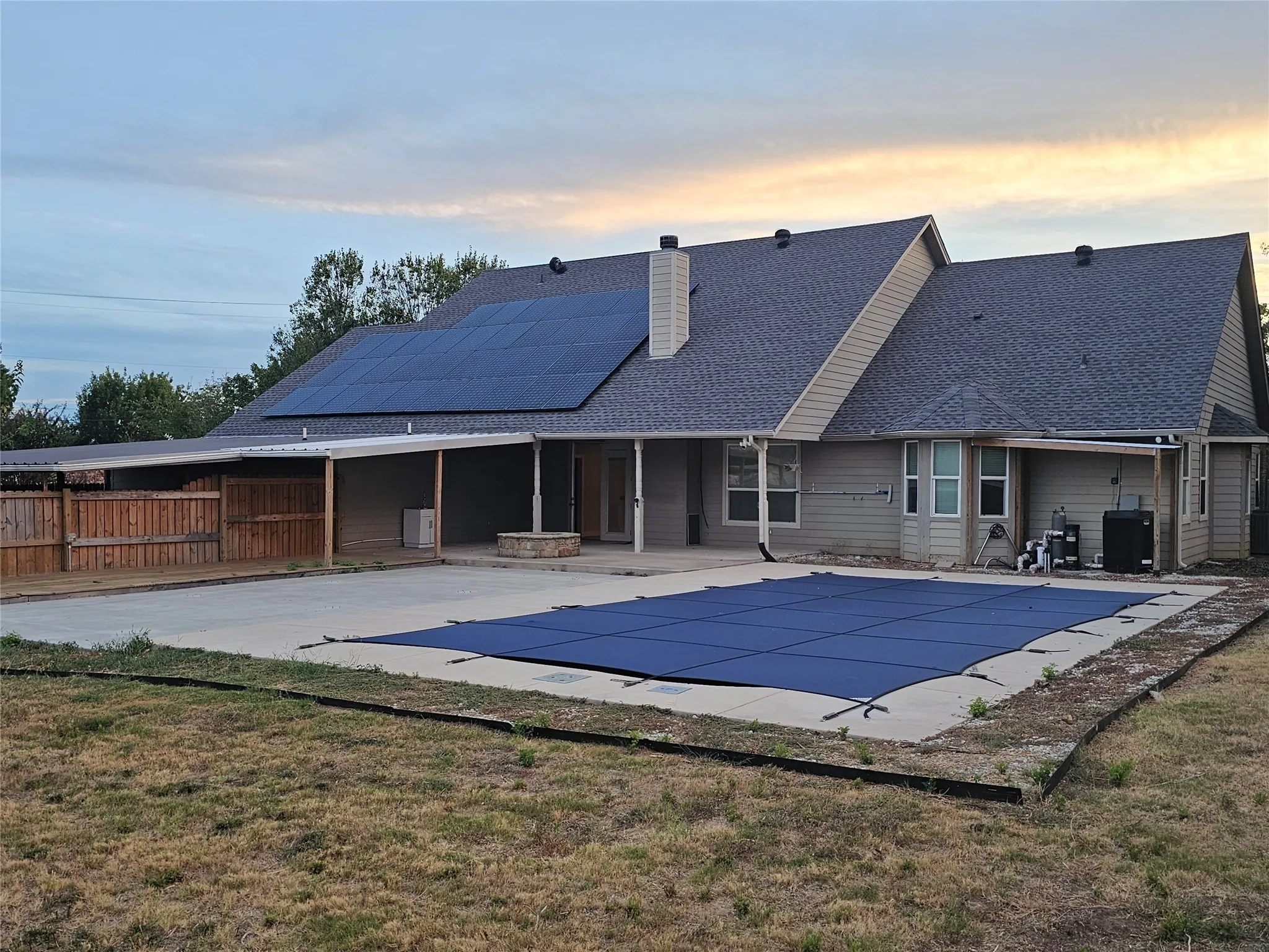 Solar panels, covered patio, privacy fence, built-in fire pit, and inground pool