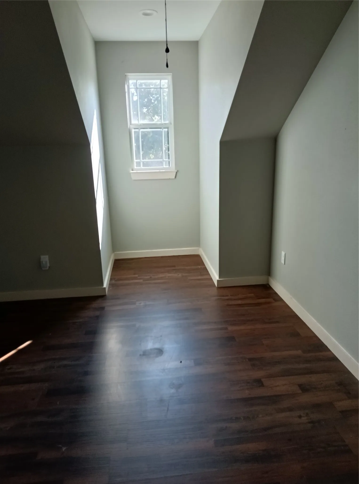 Wood-finish flooring, white trim, recessed lighting, and a double-hung window