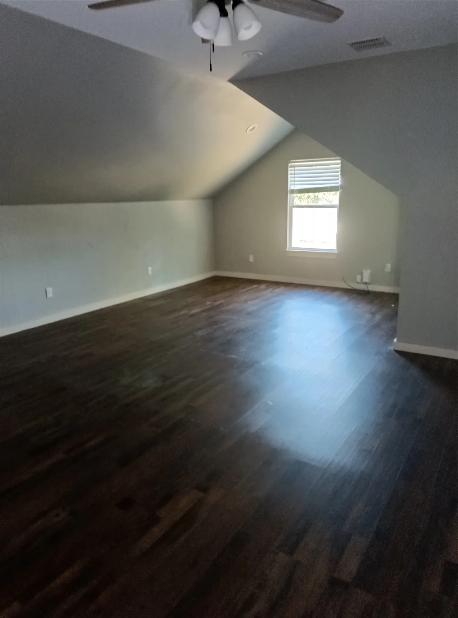 Expansive room featuring wood-finish flooring, a ceiling fan, recessed lighting, and a window with blinds