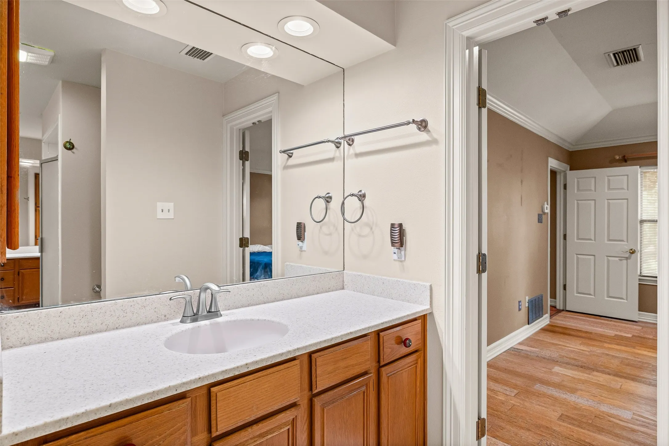 Wood-finish vanity with a white countertop and integrated sink