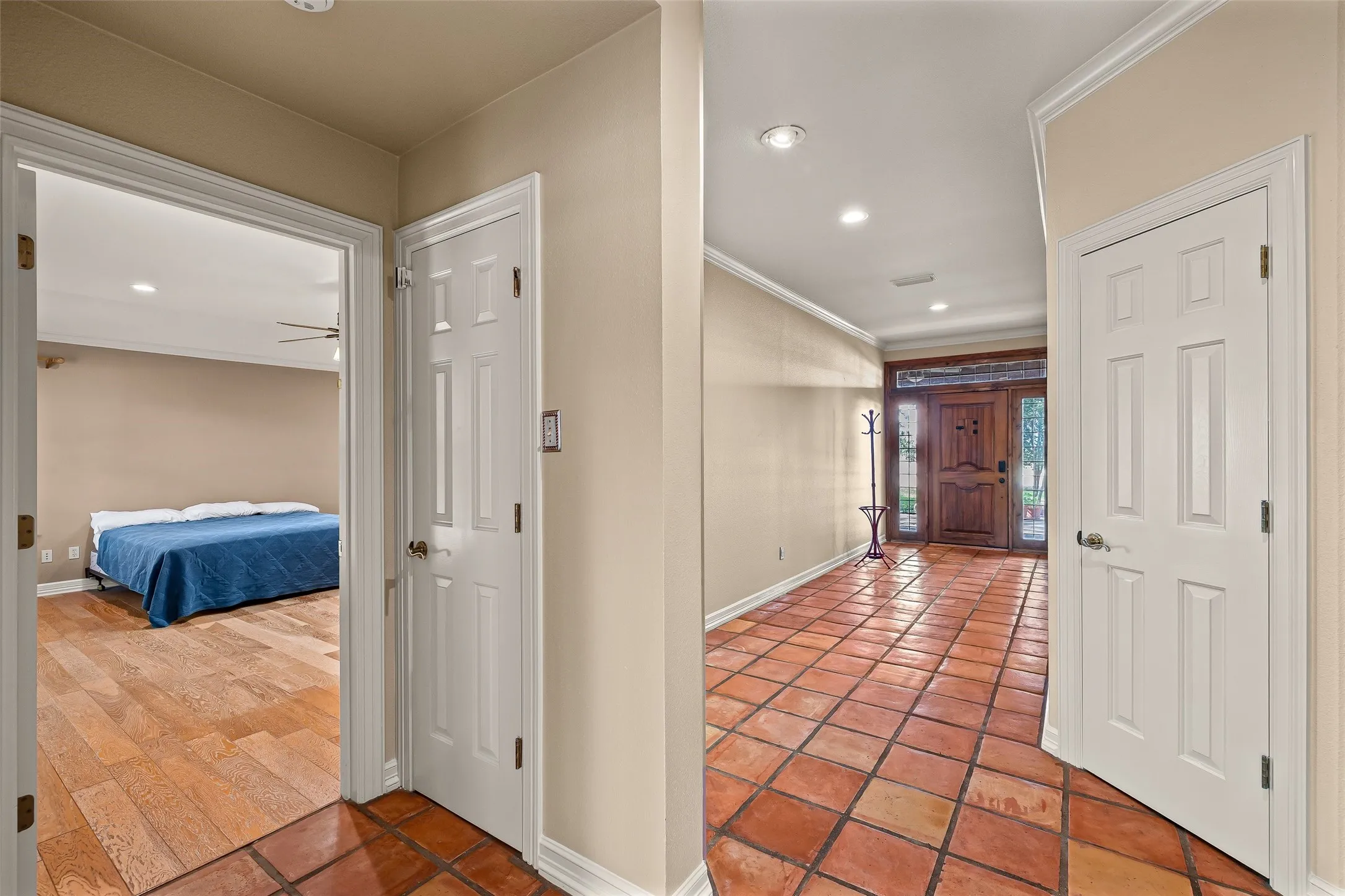 Entryway featuring terracotta tile flooring, recessed lighting, crown molding, and a solid wood entry door with glass sidelights