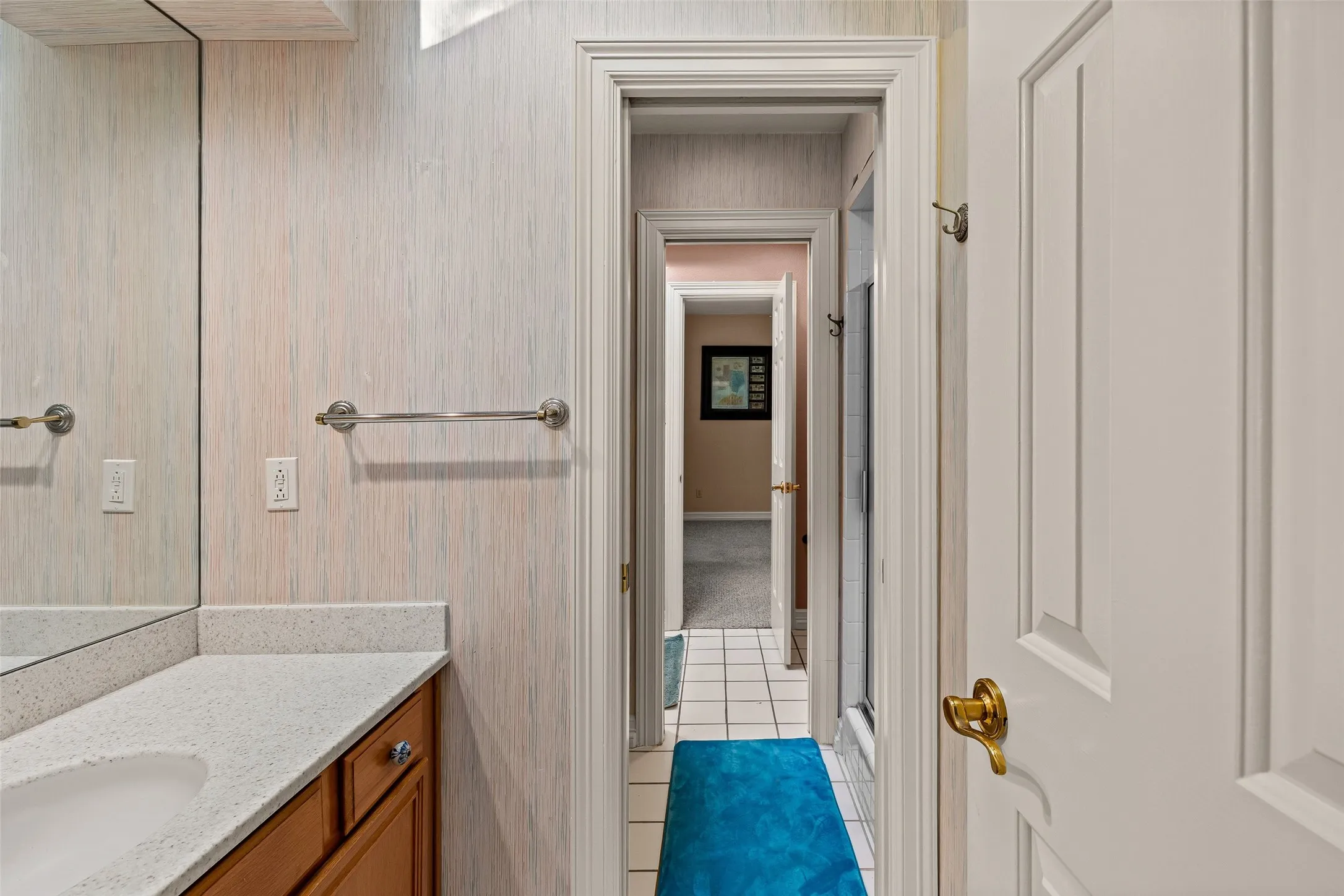 Bathroom vanity with an integrated sink, light-colored countertop, and wood-finish cabinetry