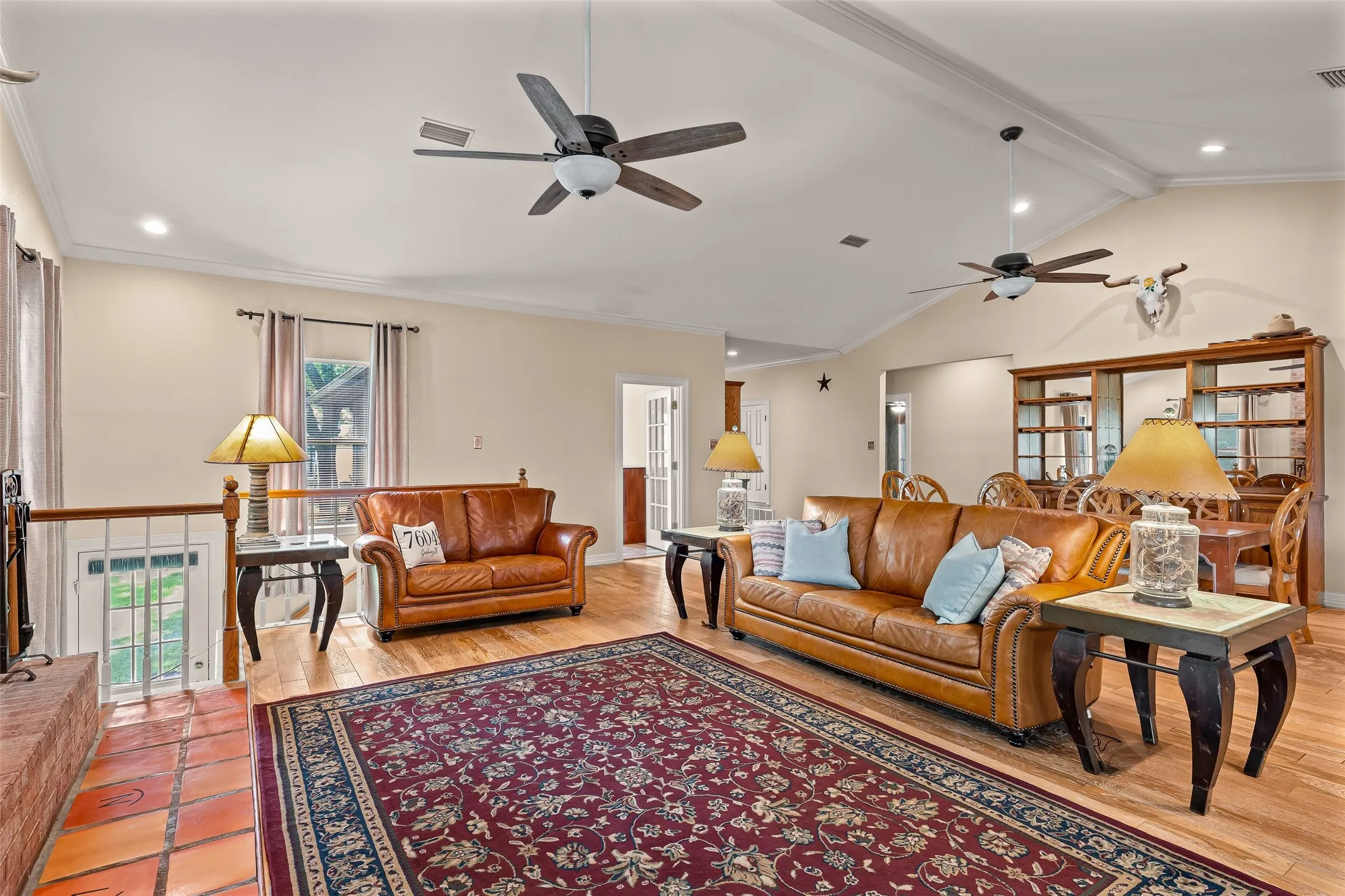 Vaulted ceilings, exposed beams, recessed lighting, wood-finish flooring, and terracotta tile flooring