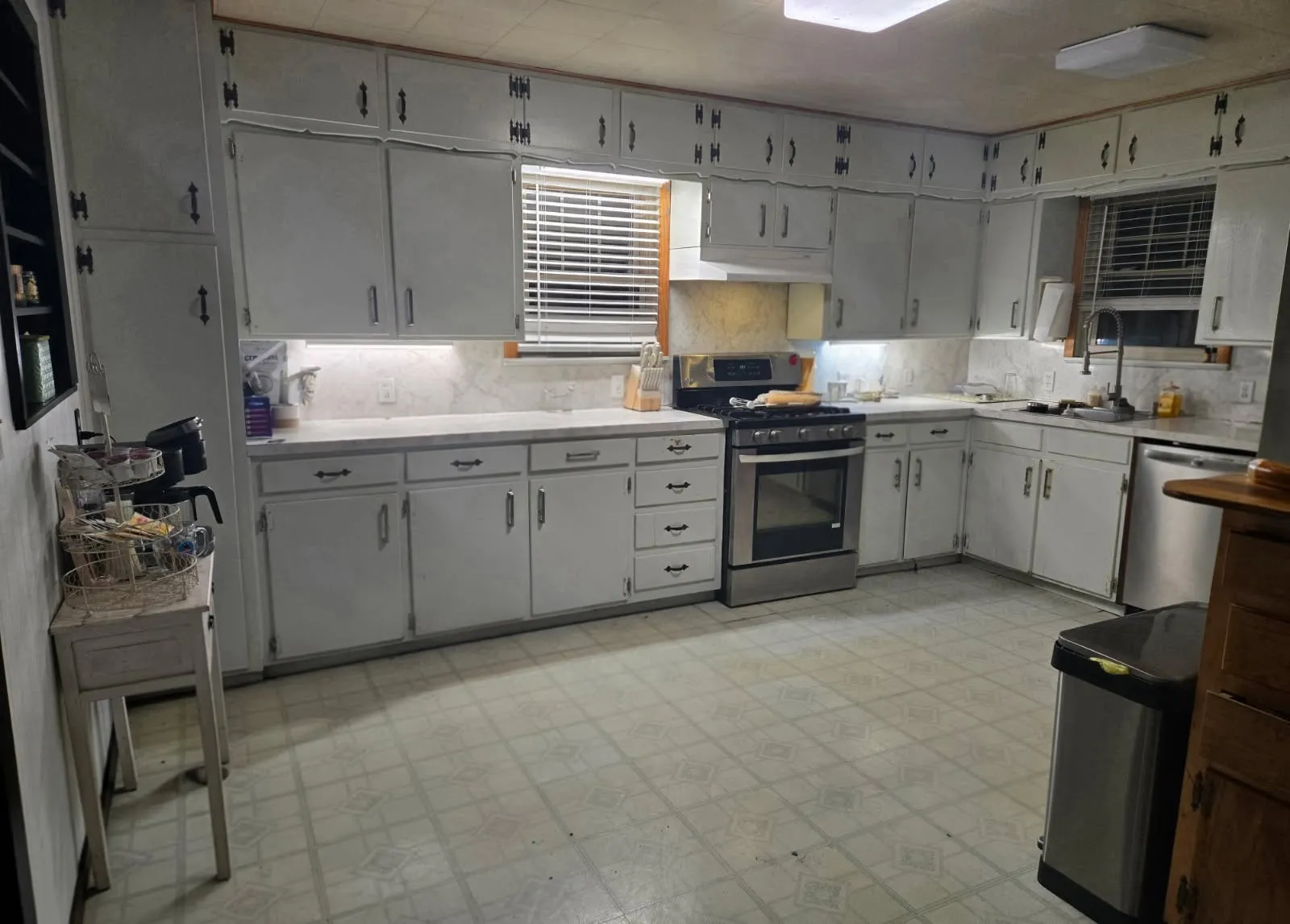Kitchen featuring white cabinetry, light-toned countertops, a stainless steel range, and a stainless steel dishwasher
