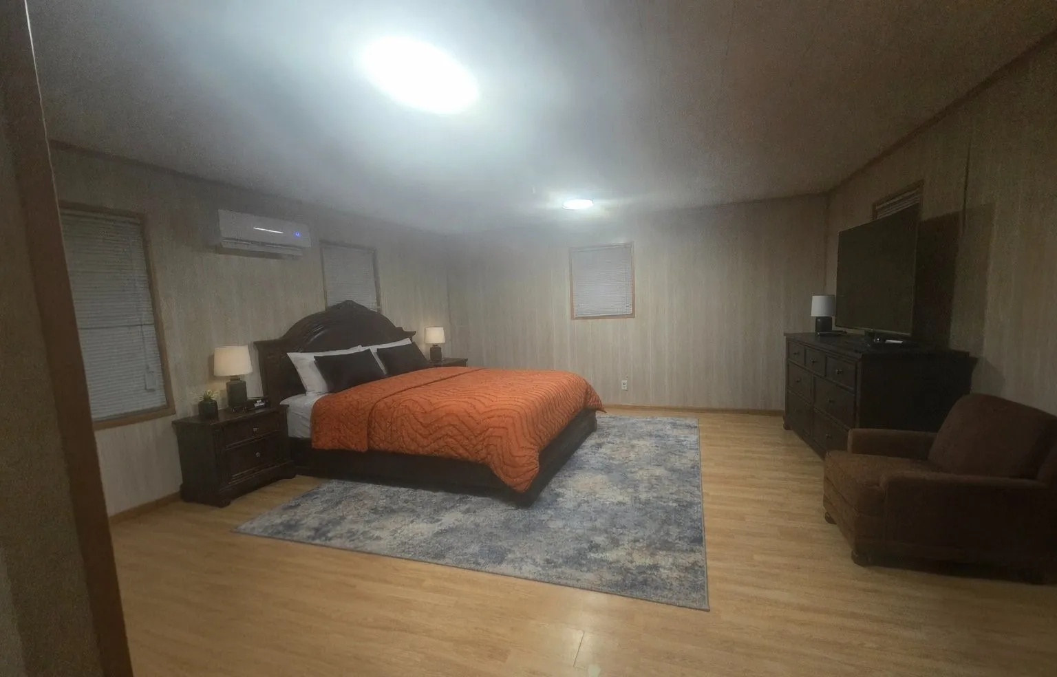 Wood-finish flooring, recessed lighting, and a wall-mounted mini-split system