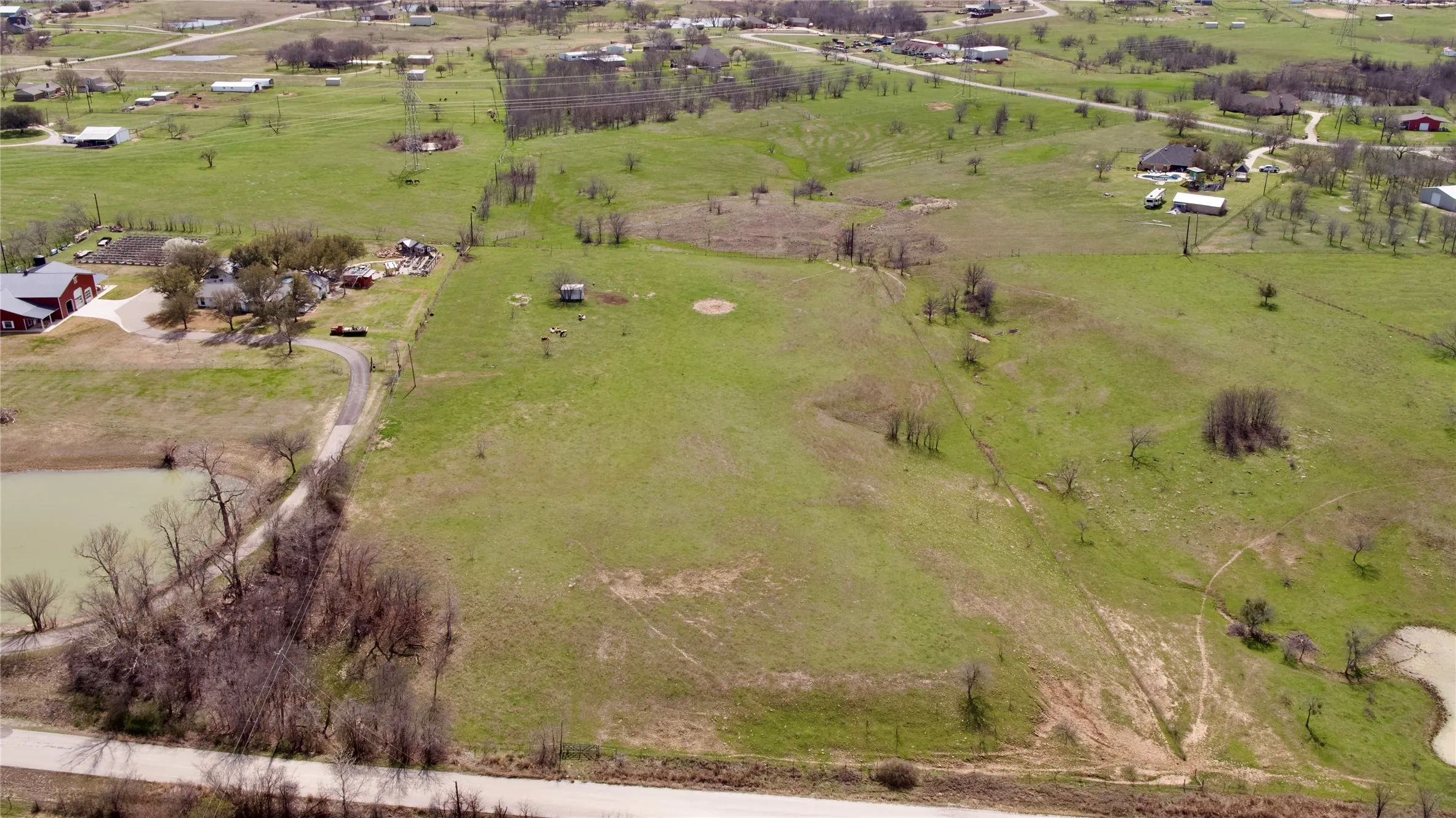 Expansive acreage featuring a pond, established road frontage, and scattered trees
