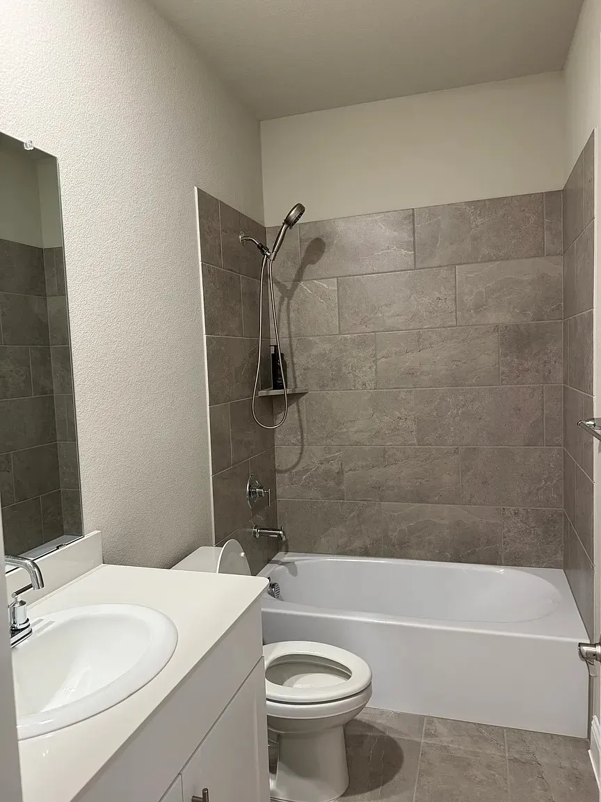 Modern bathroom featuring a white vanity with integrated sink, chrome faucet, and a large wall-mounted mirror