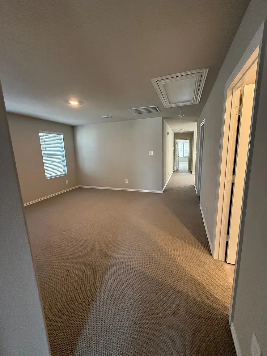 Neutral wall paint, recessed lighting, window with blinds, carpeted flooring, and a hallway