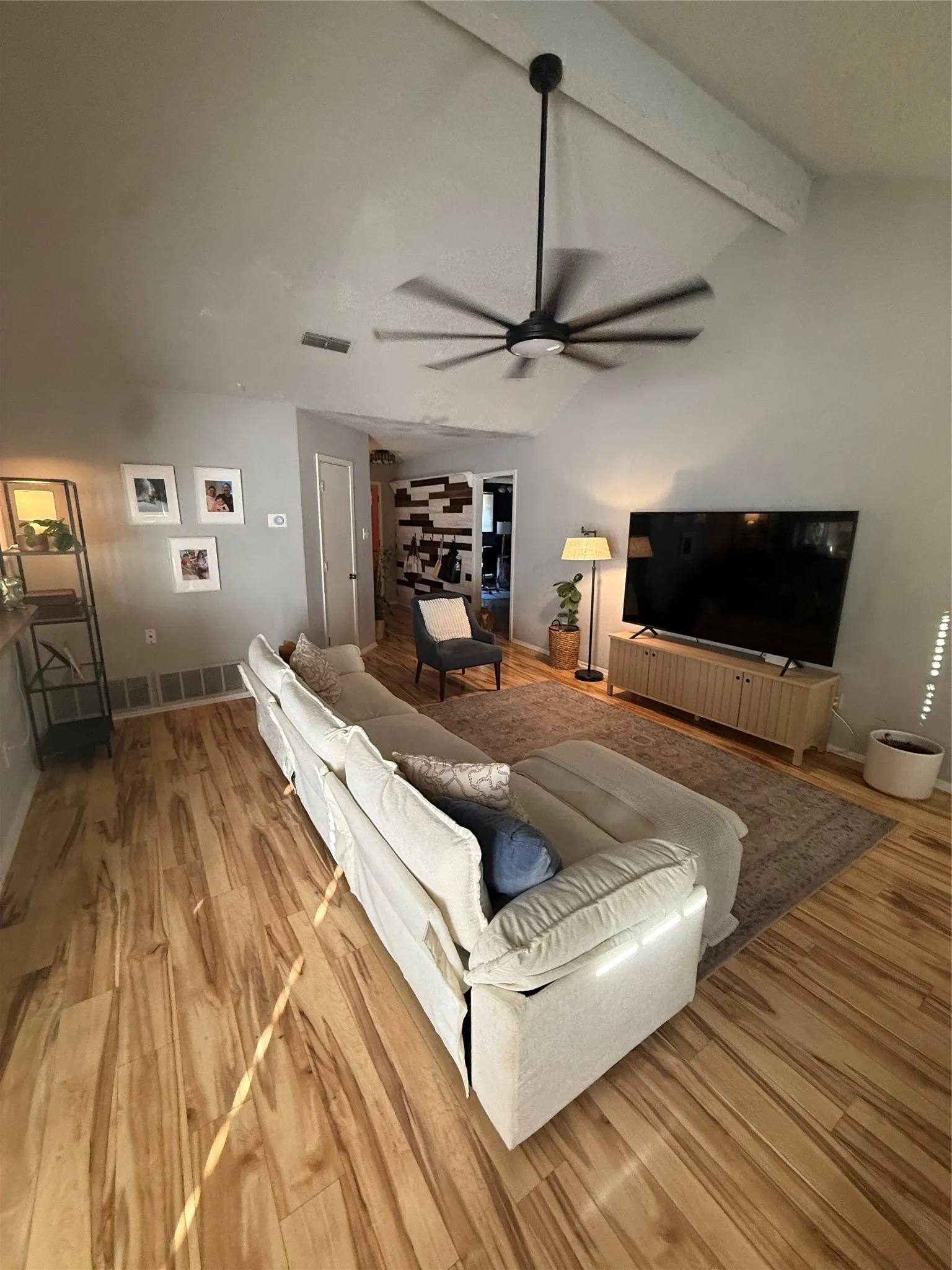Vaulted ceiling with exposed beam and a modern black ceiling fan