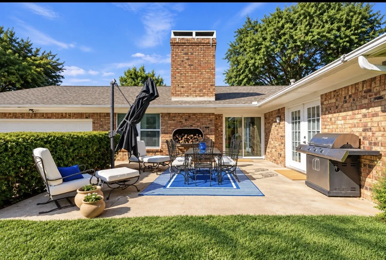 Expansive concrete patio with brick exterior and dual French doors
