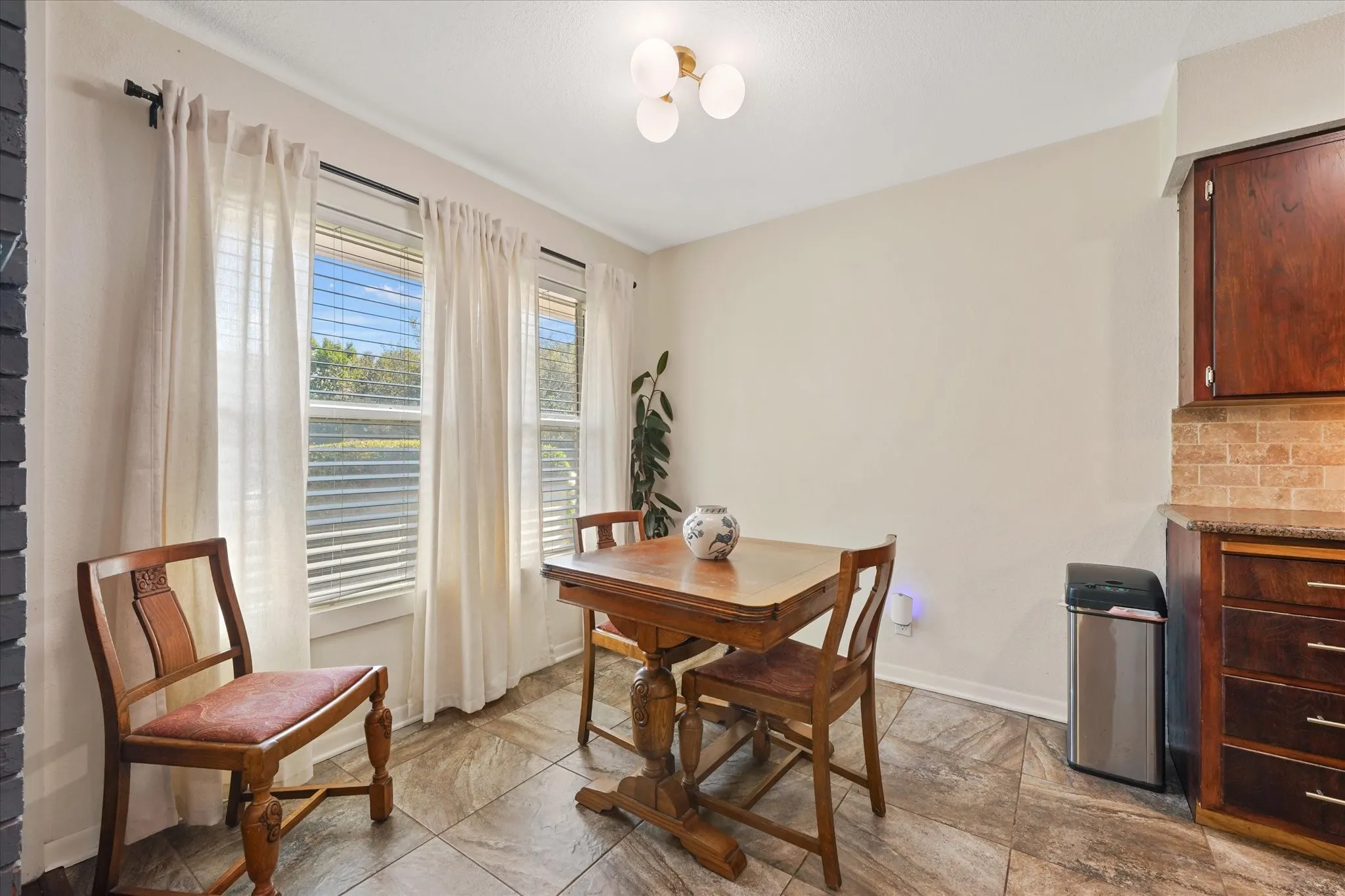 Multiple windows, tile flooring, built-in cabinetry, and a tile backsplash
