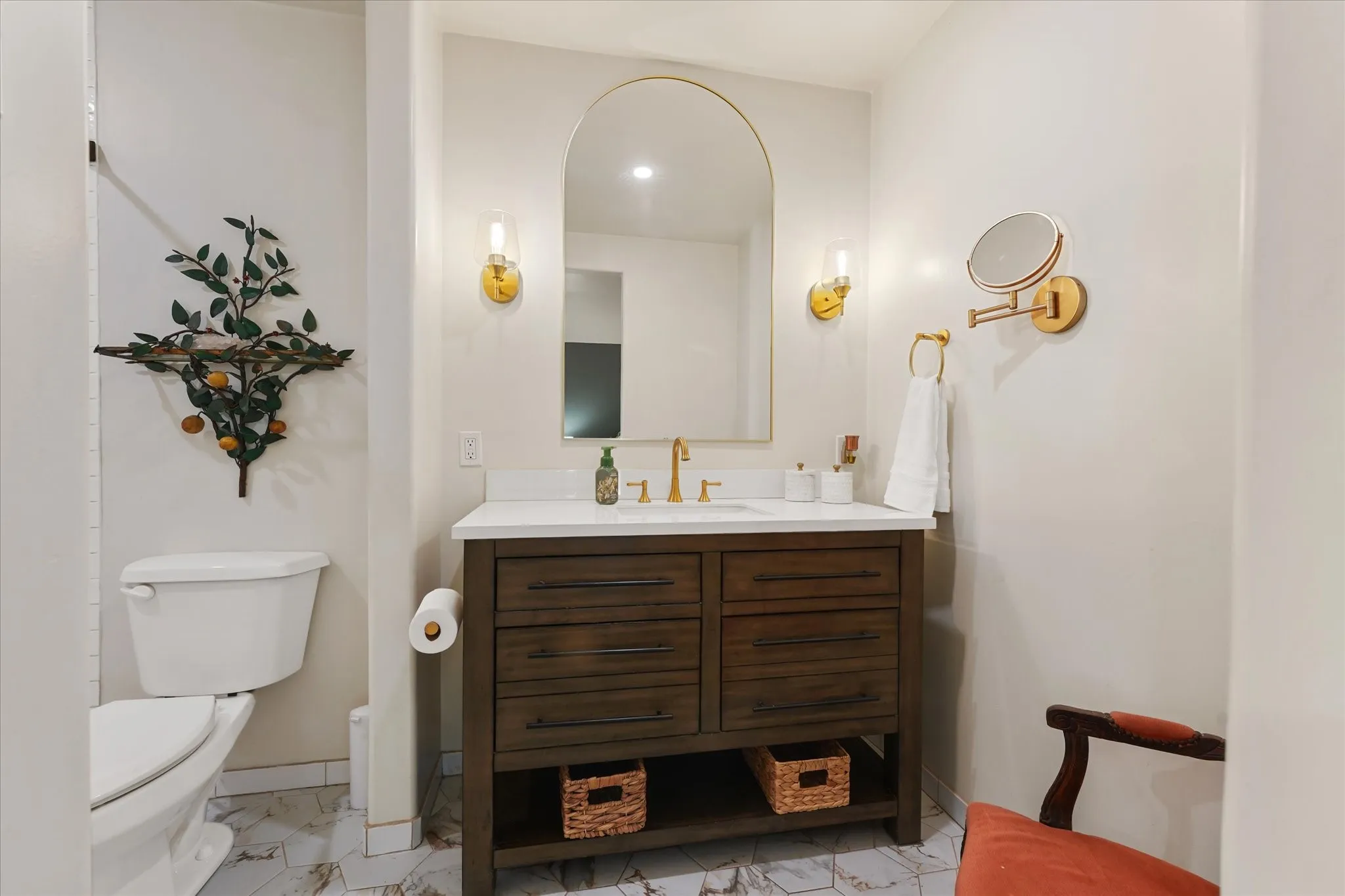 White vanity with a wood-finish base, integrated sink, and gold-tone faucet