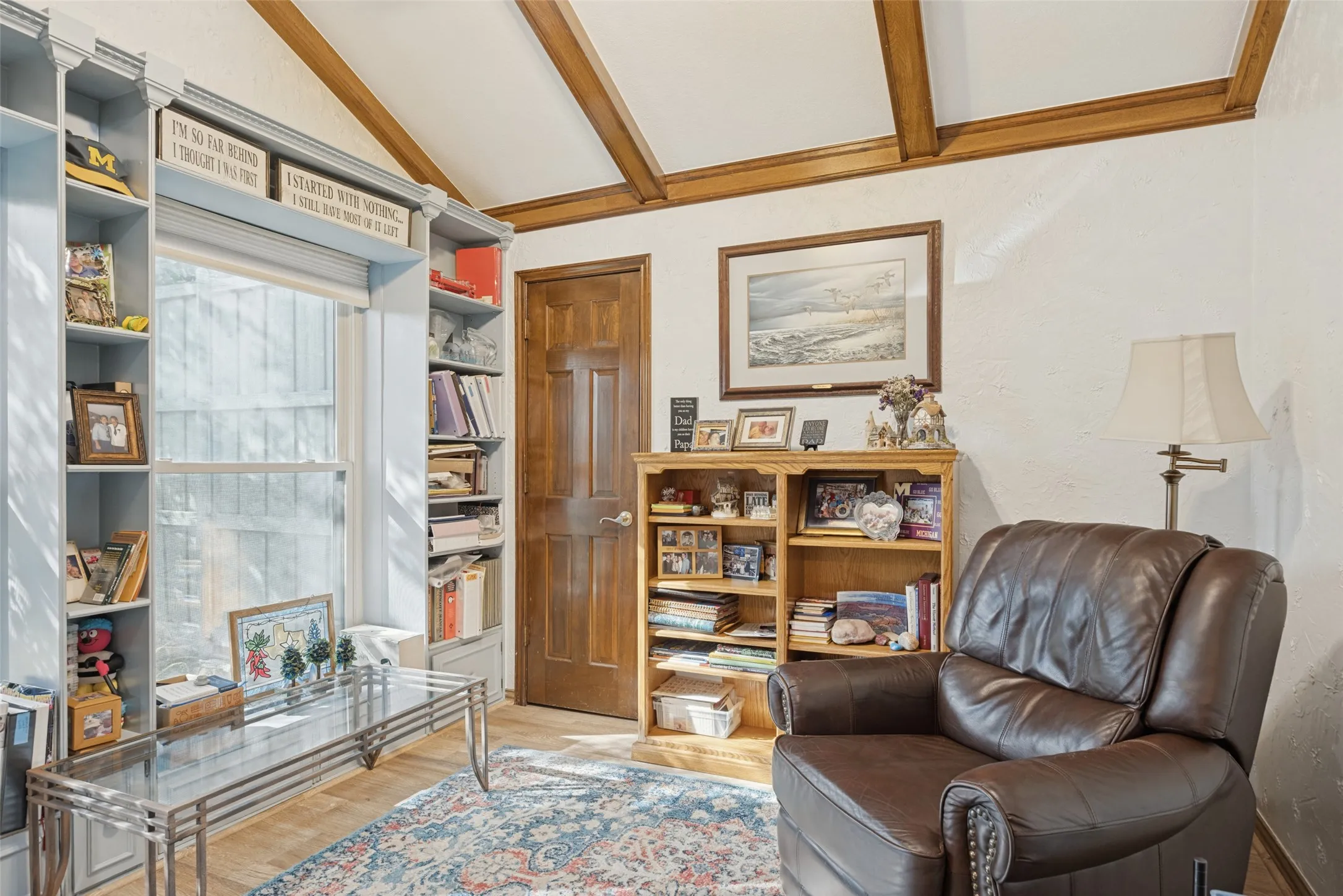 Vaulted ceiling with exposed wood beams, wood-finish flooring