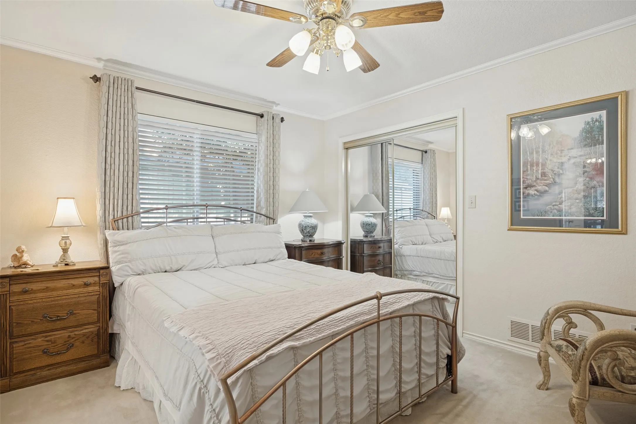 Window with blinds, ceiling fan with light fixture, carpeted flooring, and mirrored closet doors