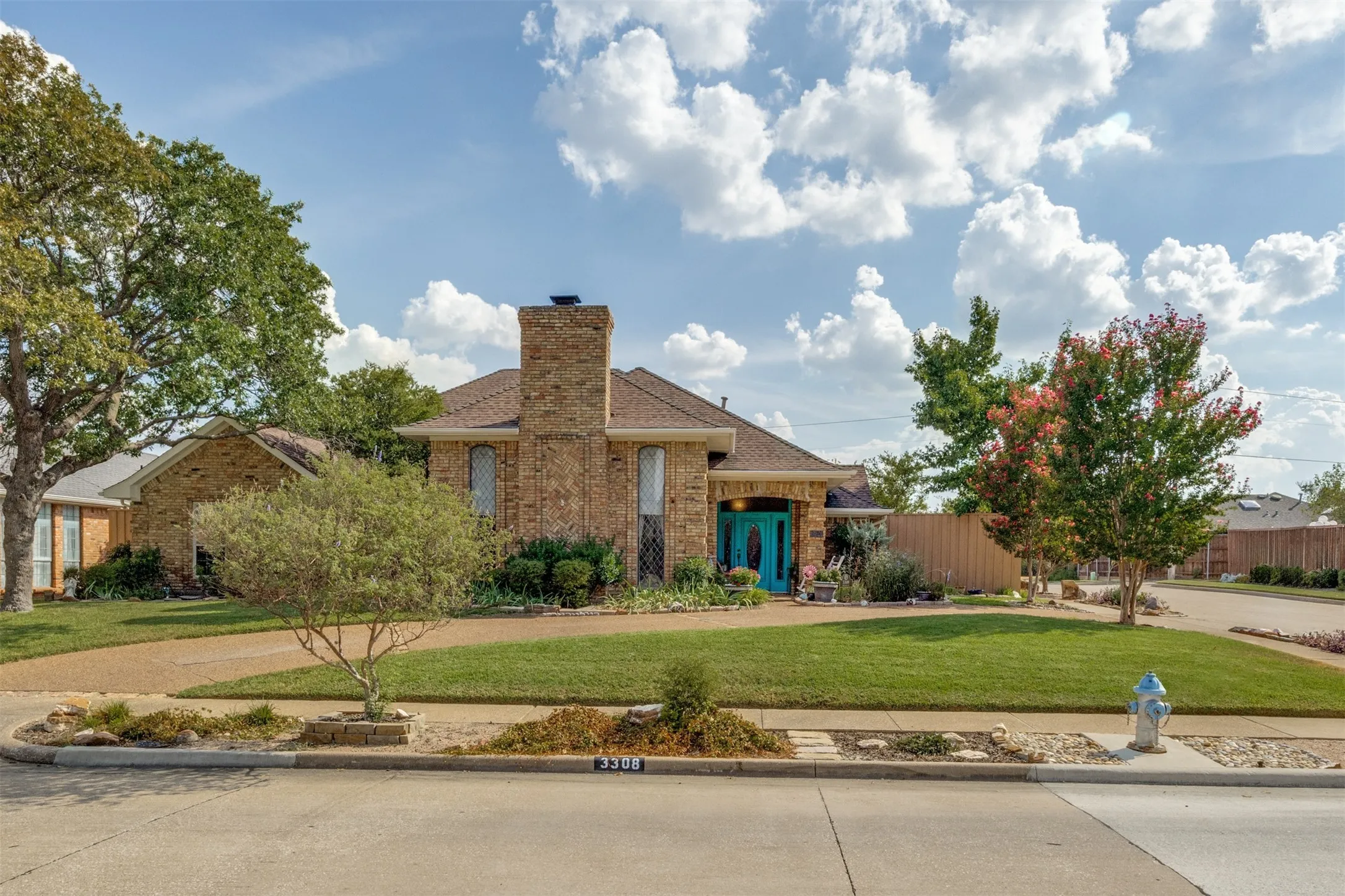 Traditional brick exterior with a circular drive, and a well-maintained lawn
