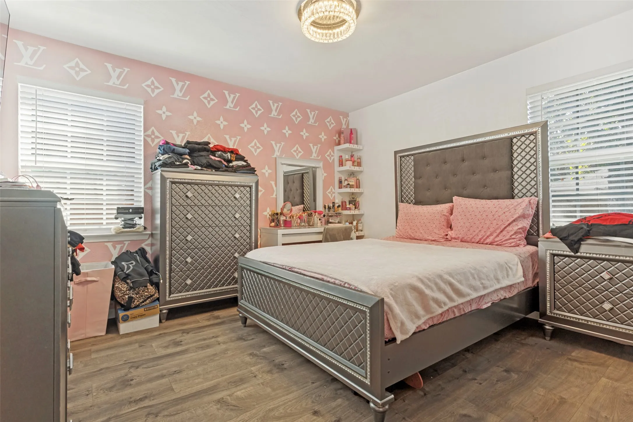 Wood-finish flooring, recessed horizontal window blinds, and built-in wall shelving