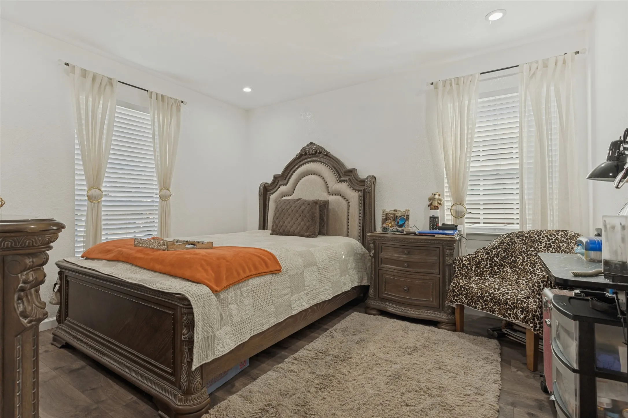 Neutral interior space featuring wood-finish flooring, recessed lighting, and dual windows with horizontal blinds