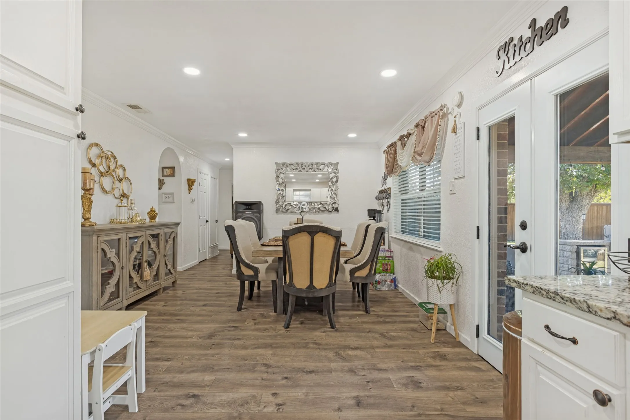 Open-concept dining area featuring wood-finish flooring, recessed lighting, and full-glass French doors