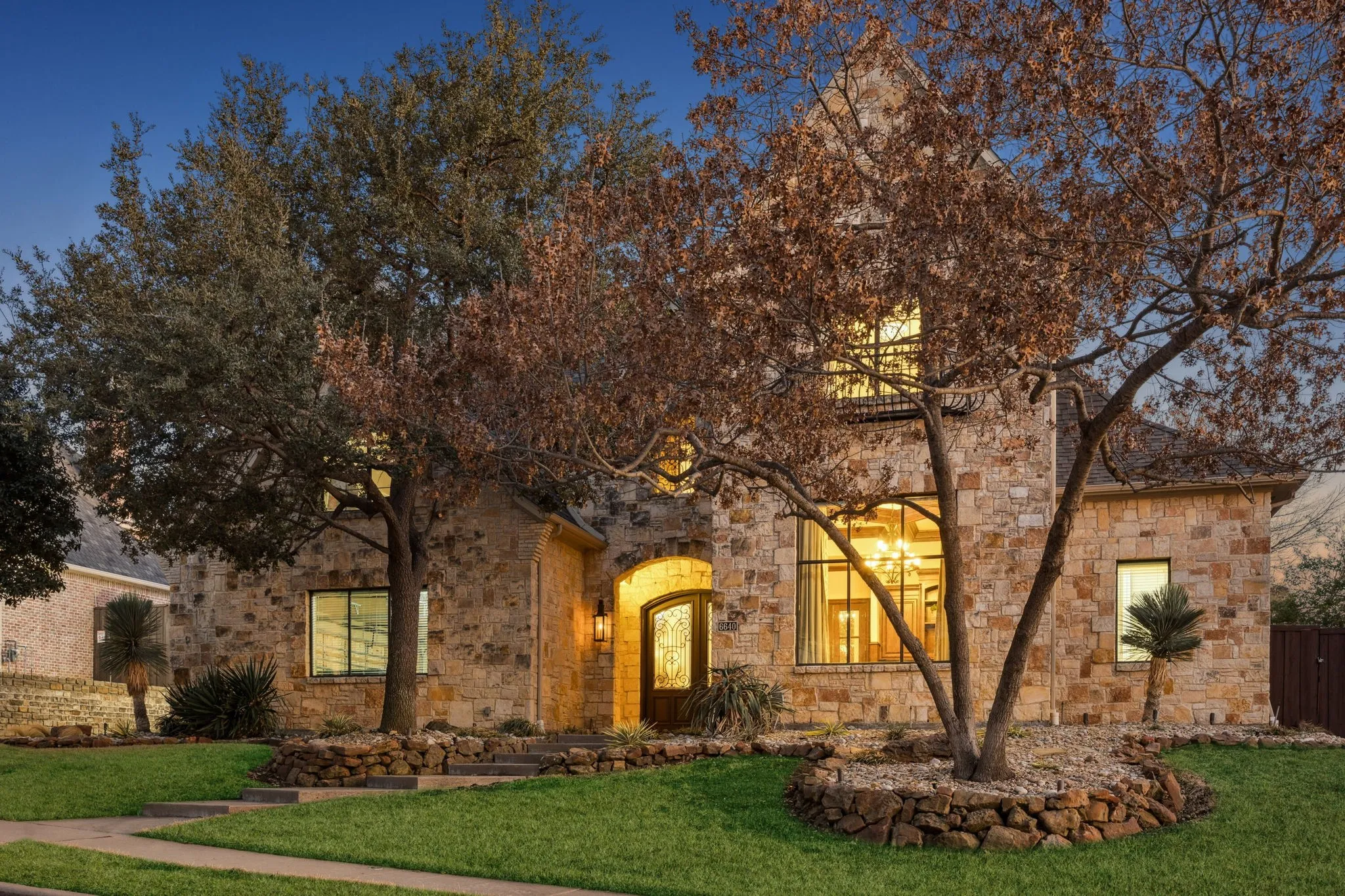 Stone exterior with arched entry, multi-pane windows, and a prominent front gable