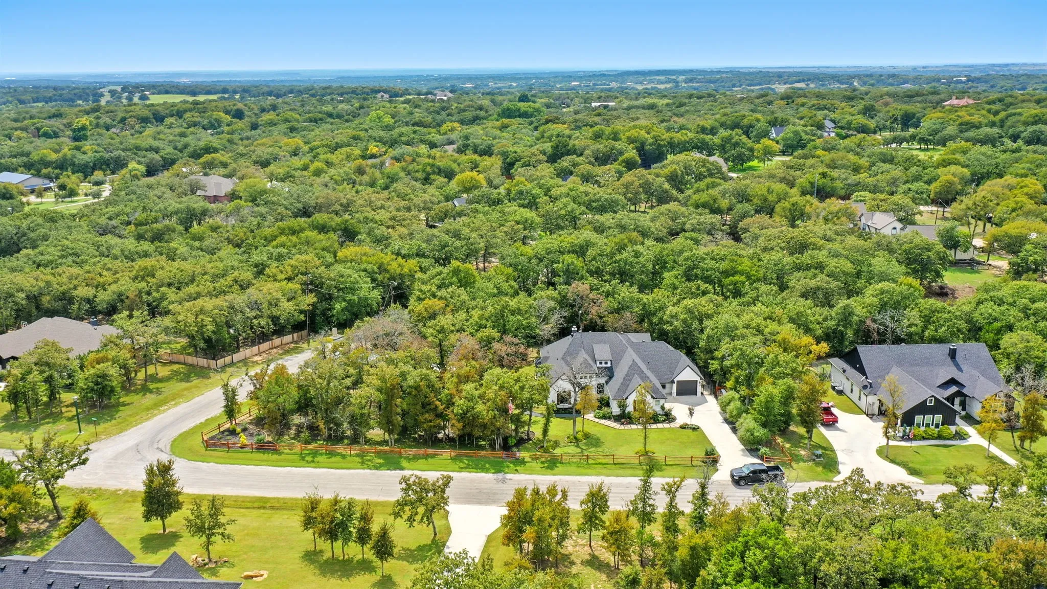 Aerial perspective showcasing the property's setting within a tree-lined landscape