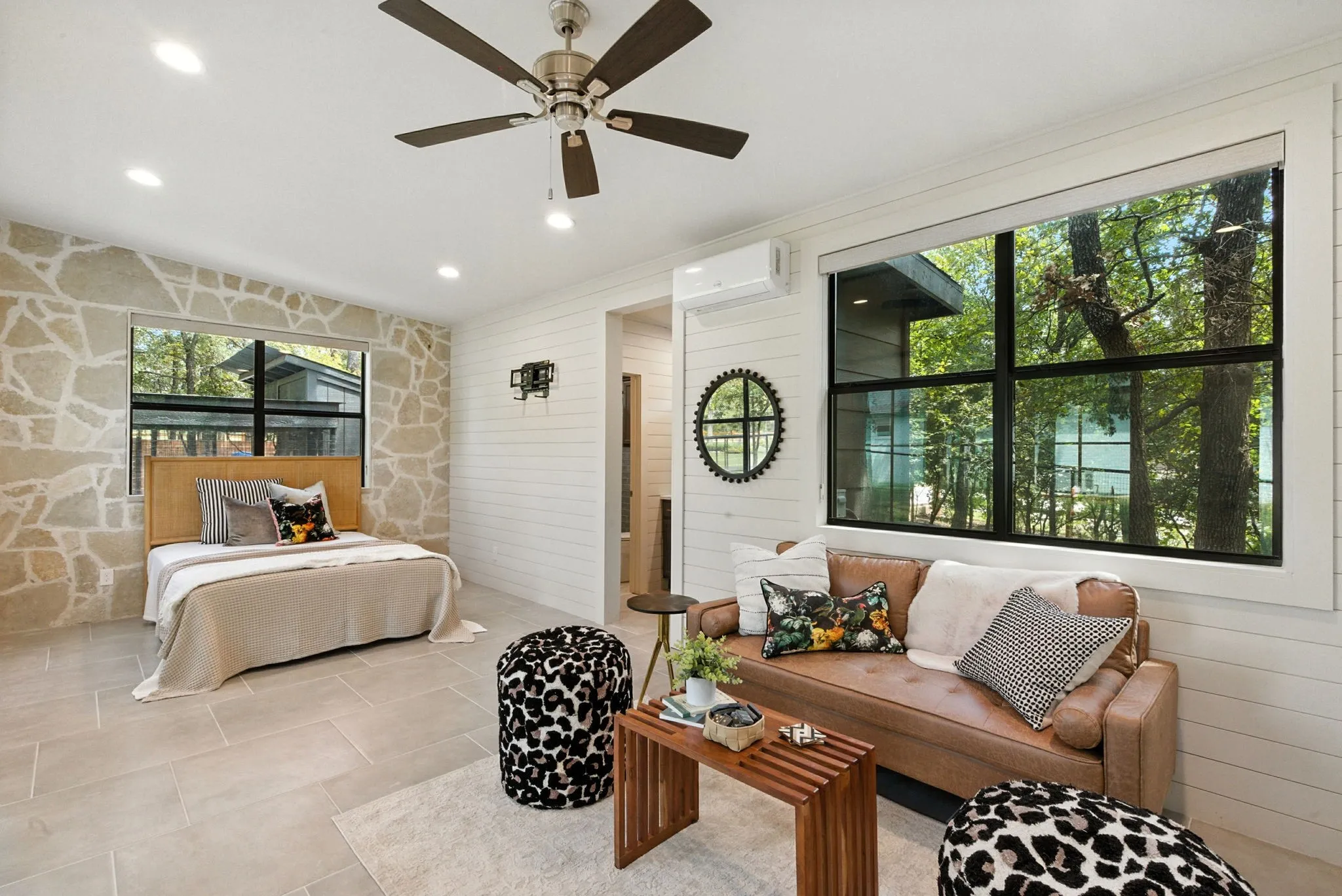 Stone accent wall, wood-finish ceiling fan, recessed lighting, tile flooring, shiplap wall