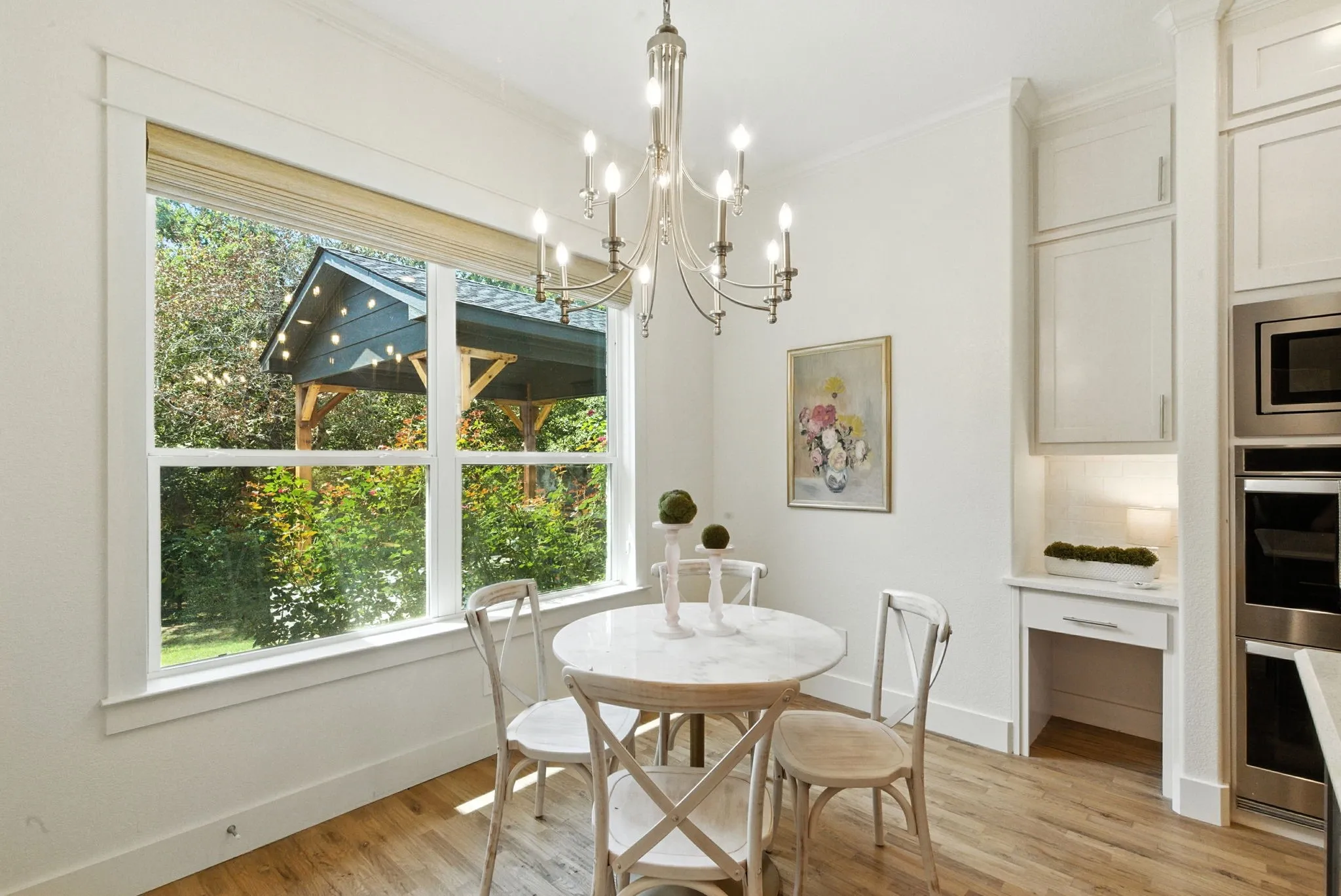Recessed lighting illuminates built-in cabinetry, stainless steel appliances, and a dedicated desk nook