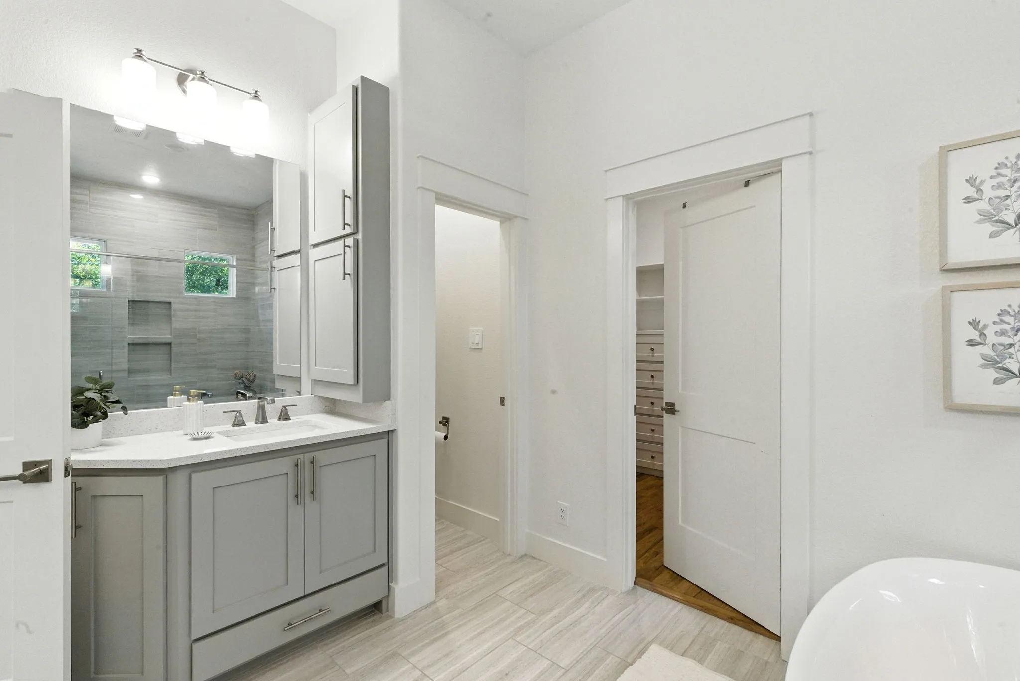Single vanity with a white countertop and undermount sink, gray cabinetry, built-in medicine cabinet, and tiled flooring