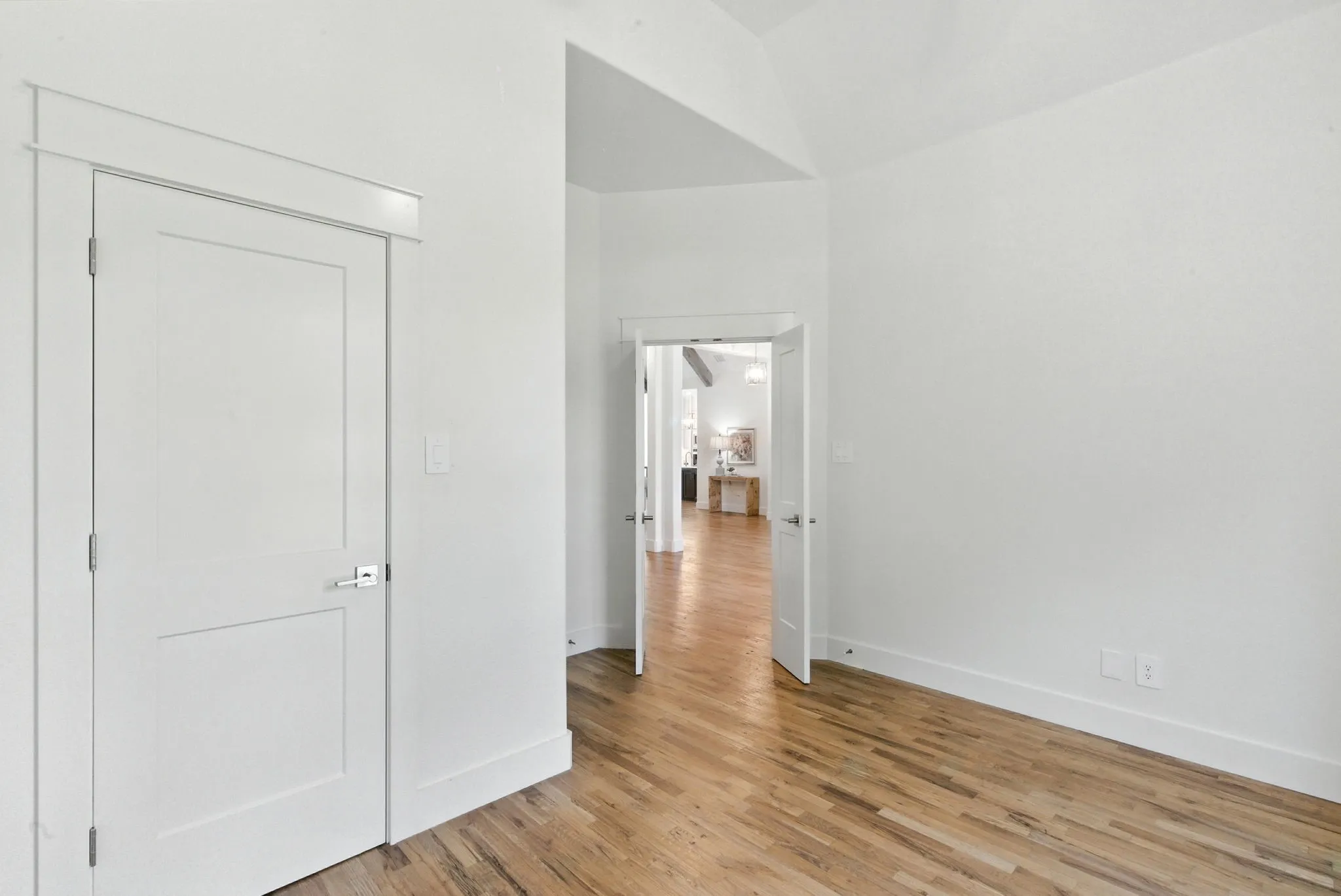 Hardwood flooring, painted interior doors with chrome hardware, and vaulted ceiling