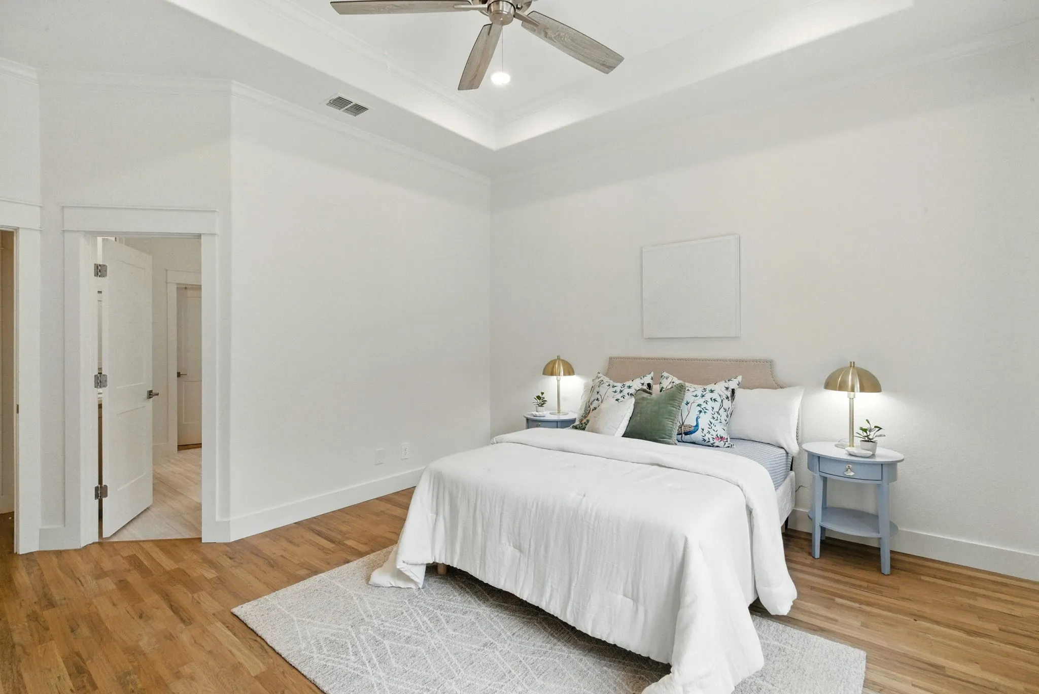 Wood-finish flooring with crisp white walls and a tray ceiling