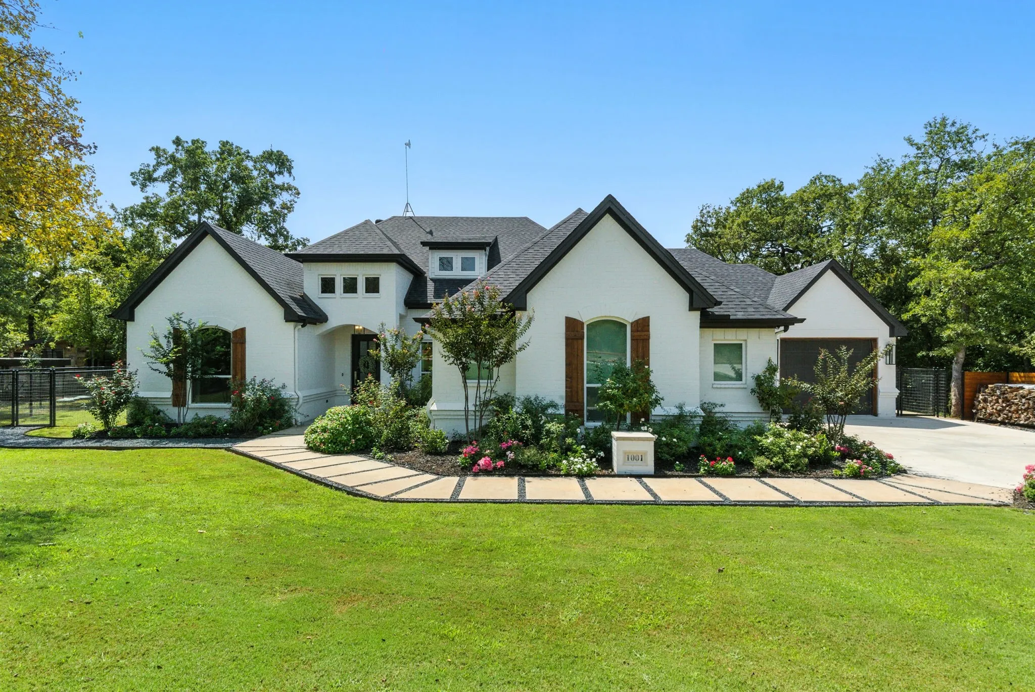 White stucco exterior with dark trim, prominent gables, and dark shingle roof