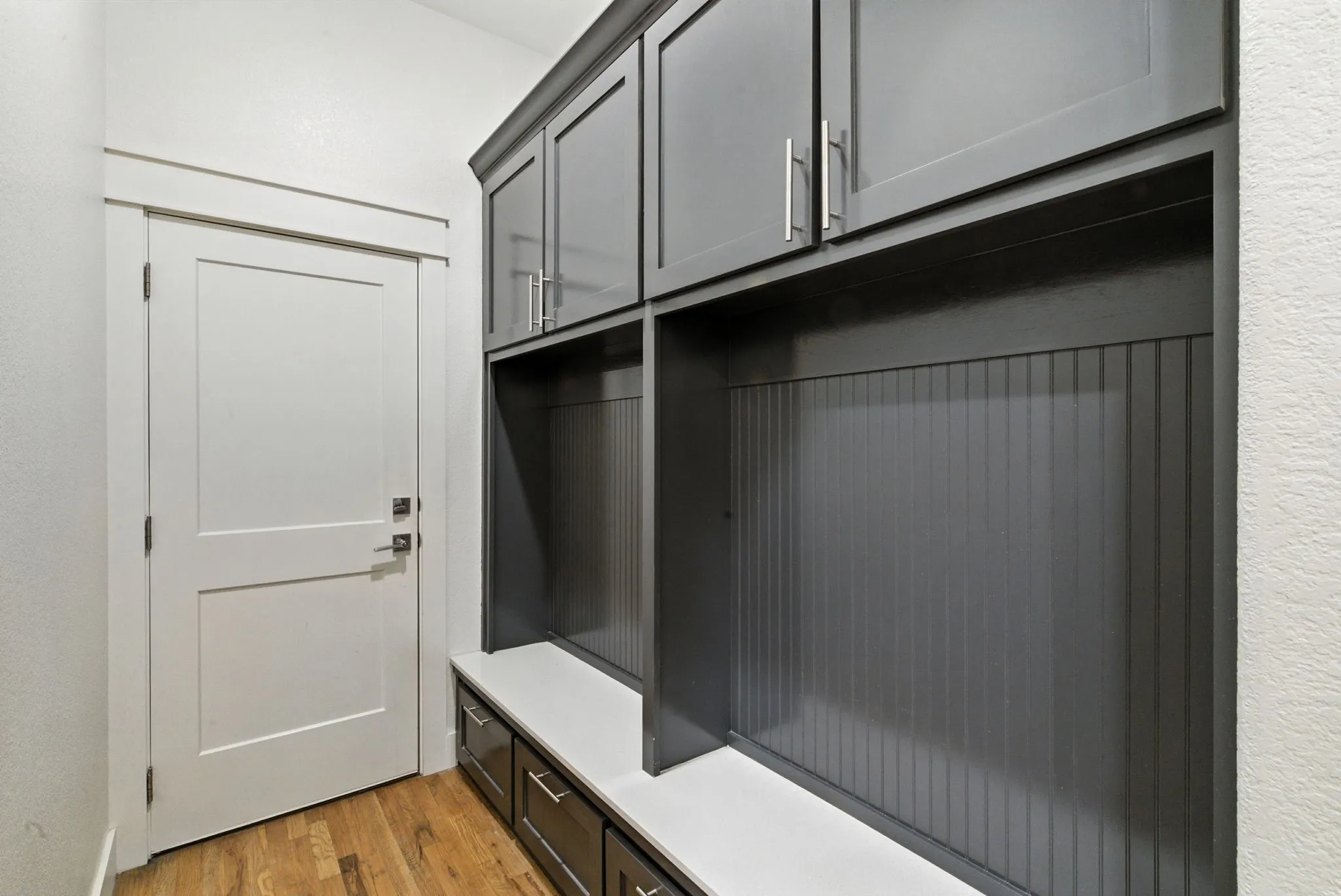 Built-in cabinetry with dark finishes, integrated storage benches, and wood-finish flooring