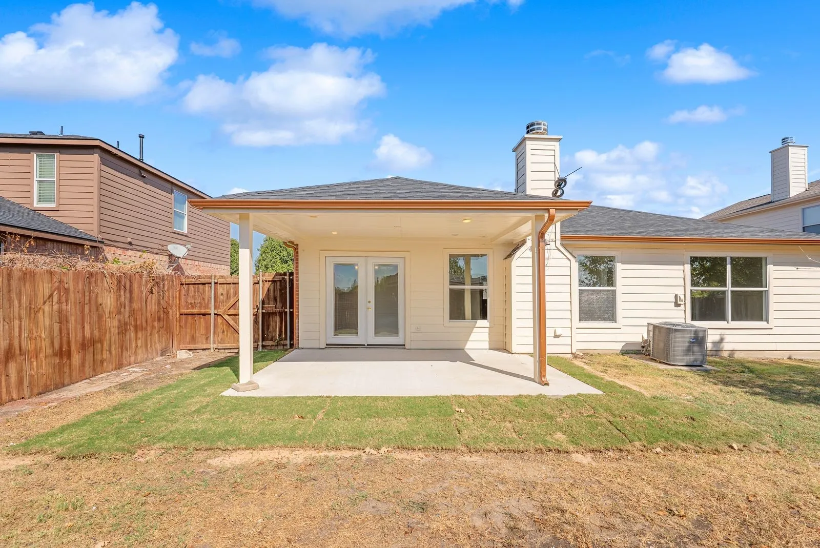 Backyard featuring a covered patio, concrete slab, and wood privacy fencing