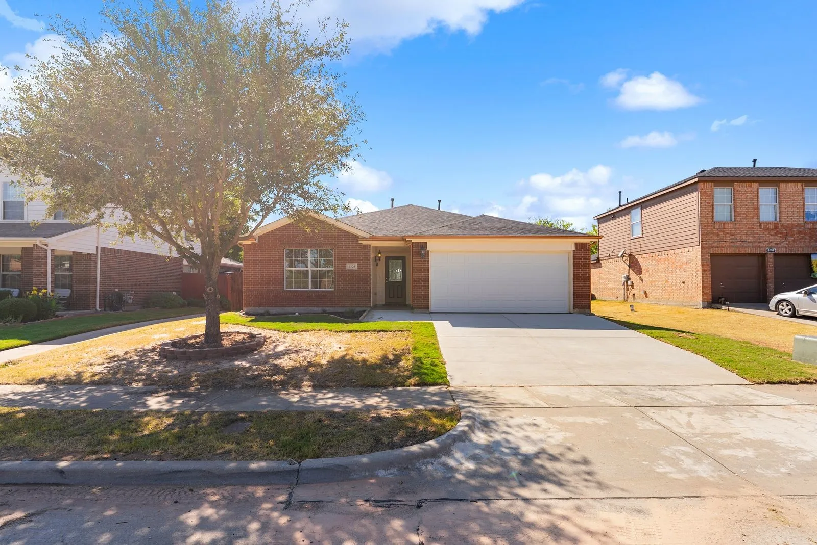 Brick exterior with a single-story design, an attached two-car garage, and a concrete driveway