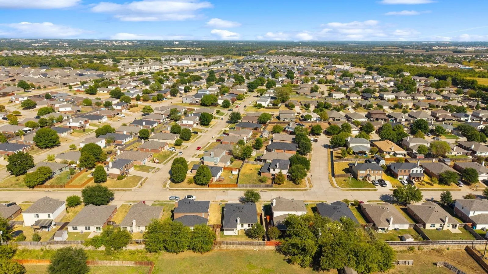 Expansive residential area featuring numerous single-family homes, mature trees, and paved streets