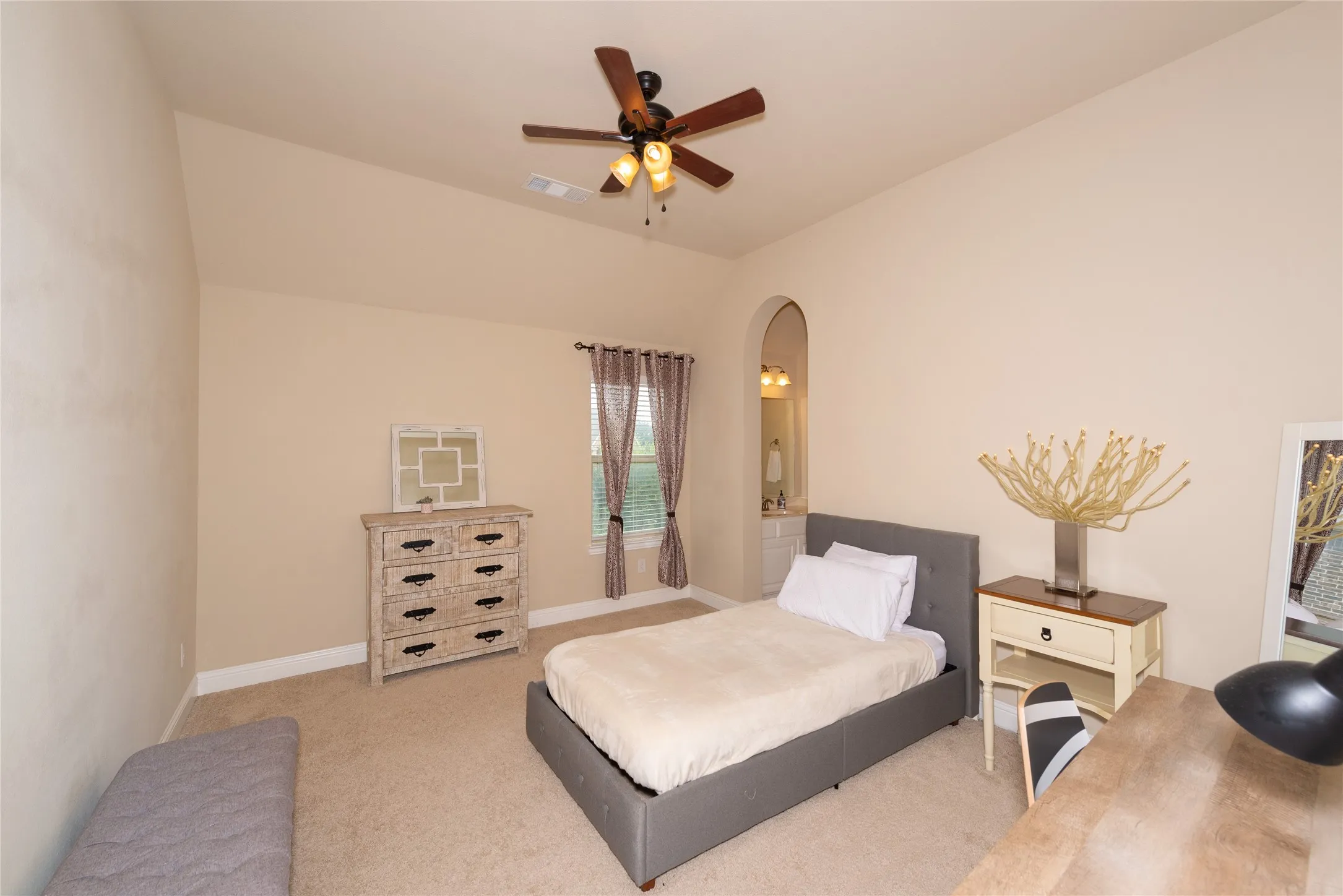 Vaulted ceiling with a ceiling fan, carpeted flooring, and a window with natural light