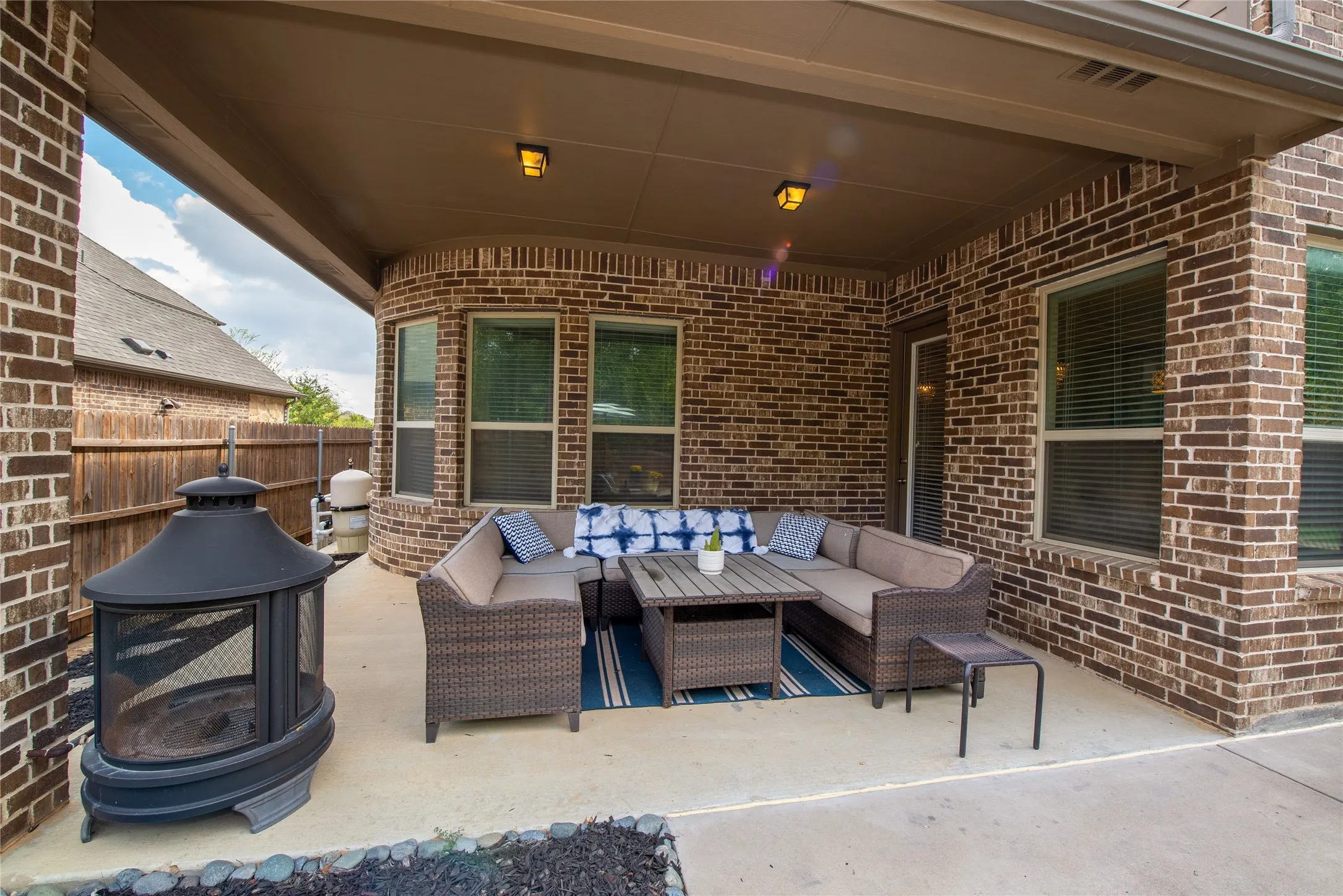 Covered patio featuring a concrete slab and brick exterior