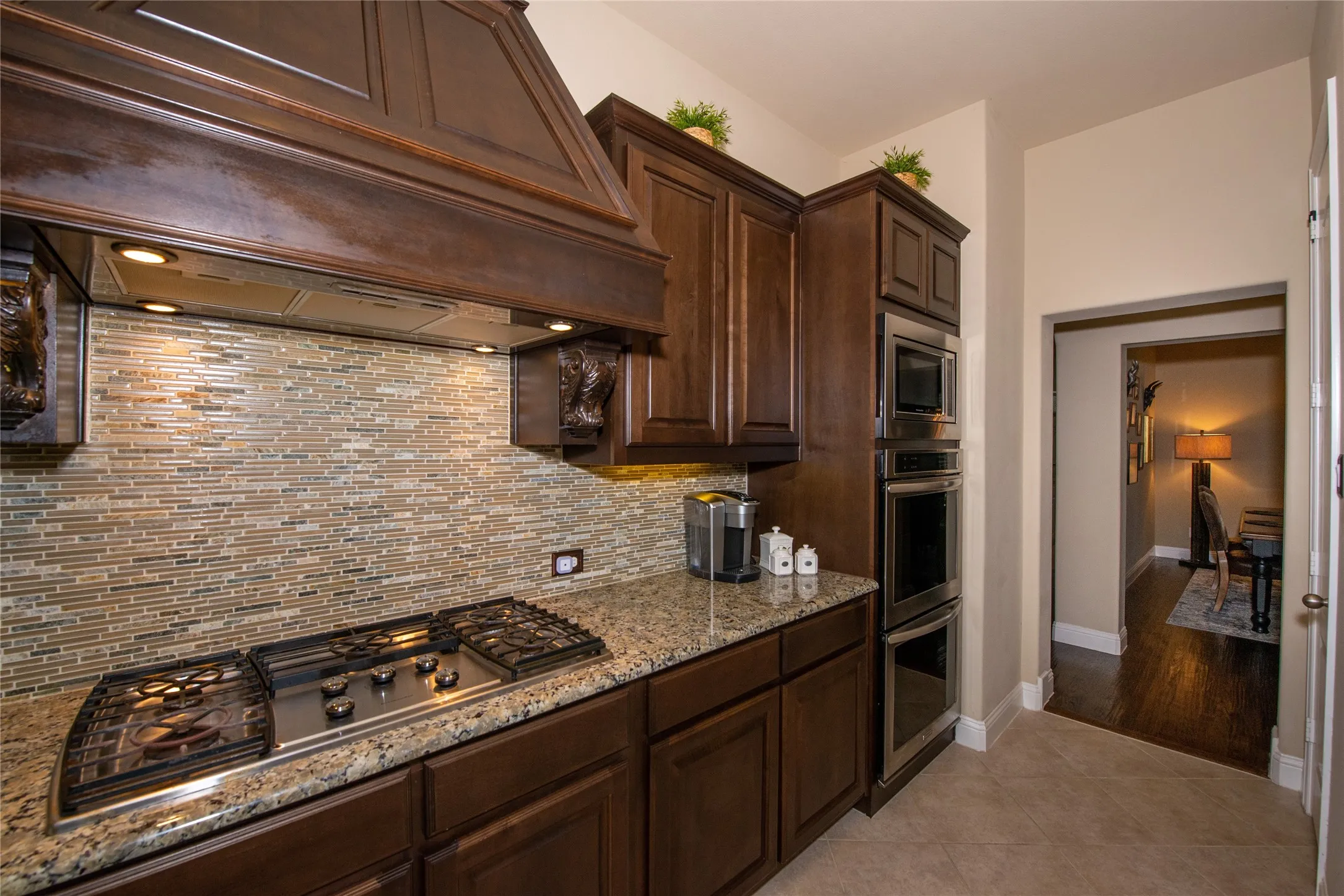 Warm wood-finish cabinetry with a built-in oven and microwave