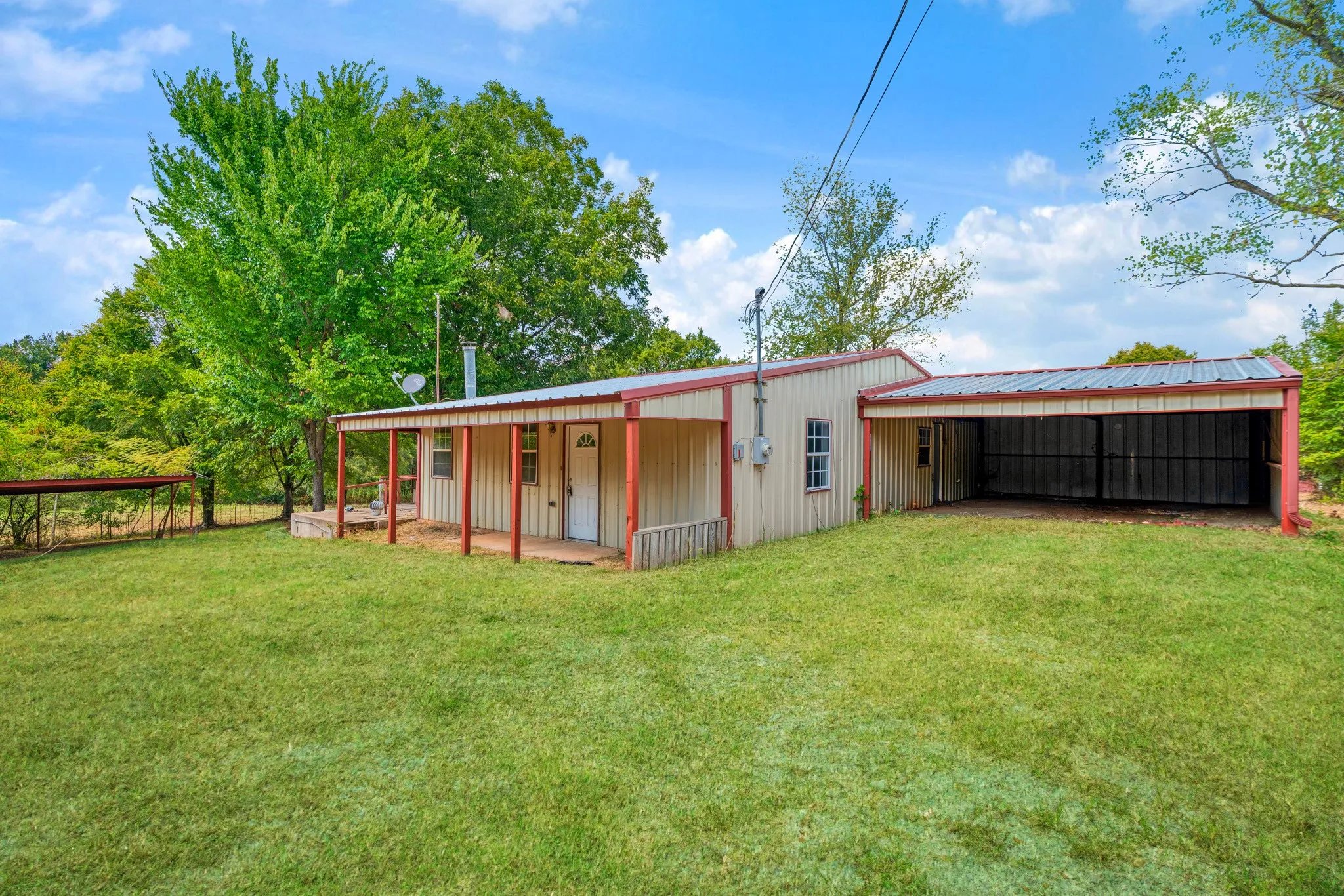 Front exterior view shows entrance, deck and carport
