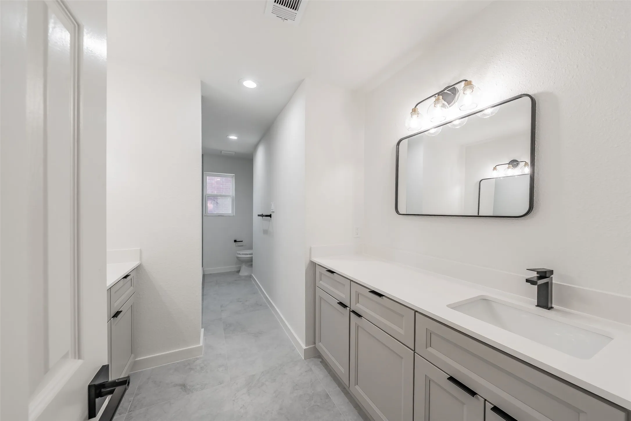 Two separate vanities with integrated sink with plenty of storage and countertop, and matte black faucet