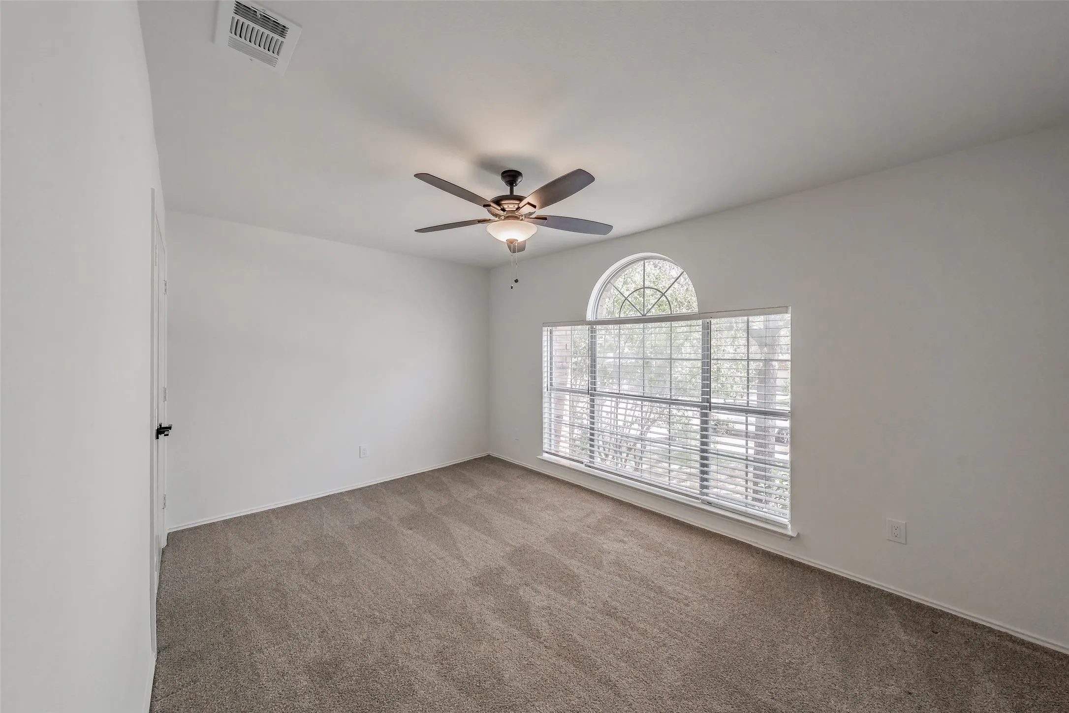 Third bedroom has large window with arched transom, carpet, ceiling fan with integrated lighting, and closet