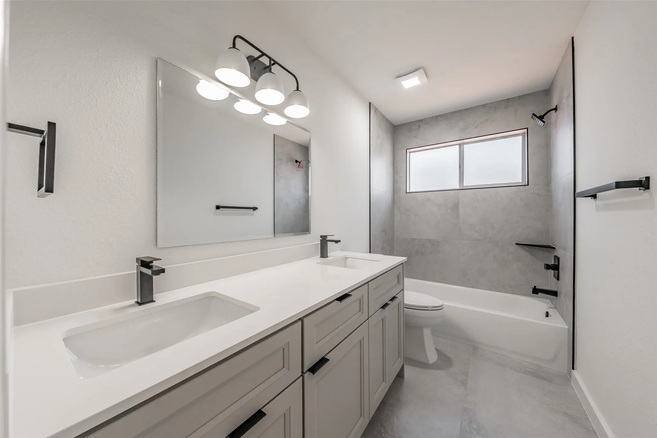 Second floor full bathroom has dual vanity with integrated sinks and black-finish faucets, and tiled bathtub/shower combo