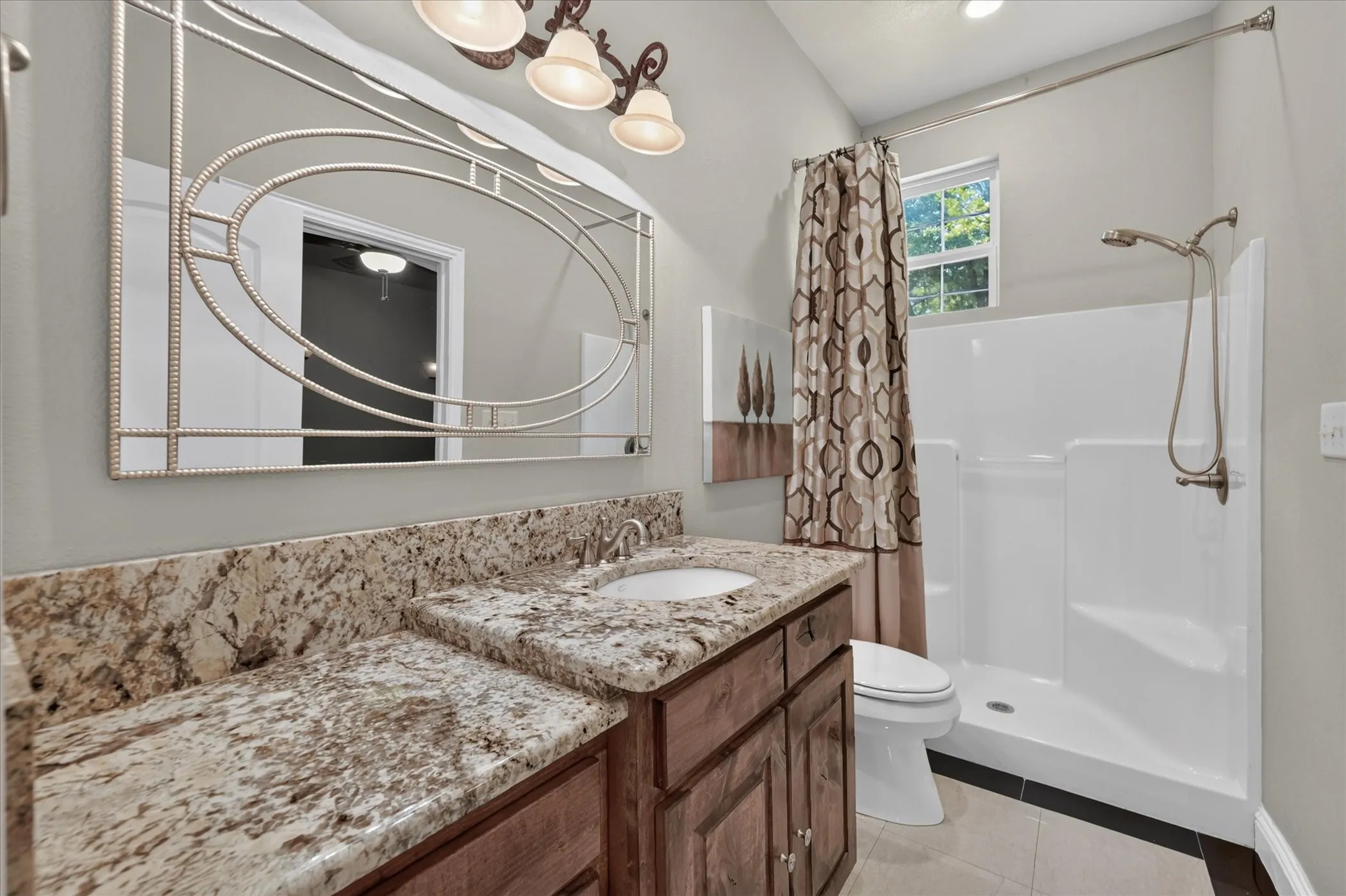 Vanity featuring a stone countertop with an undermount sink and decorative mirror