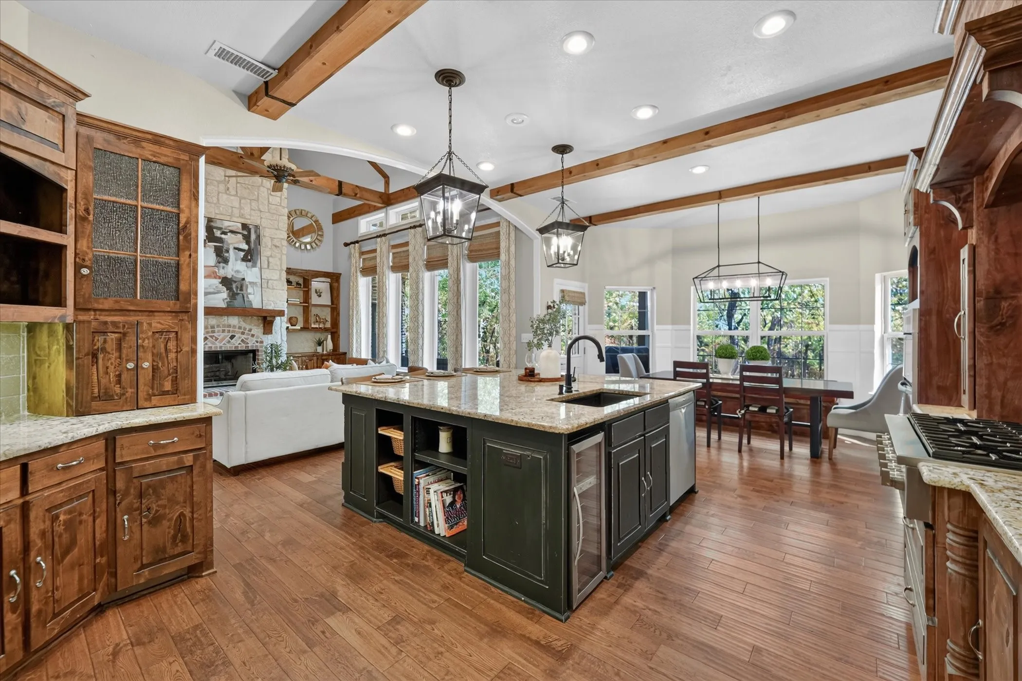 Kitchen featuring a dark wood-finish island with integrated beverage cooler, granite countertops, and wood-finish flooring