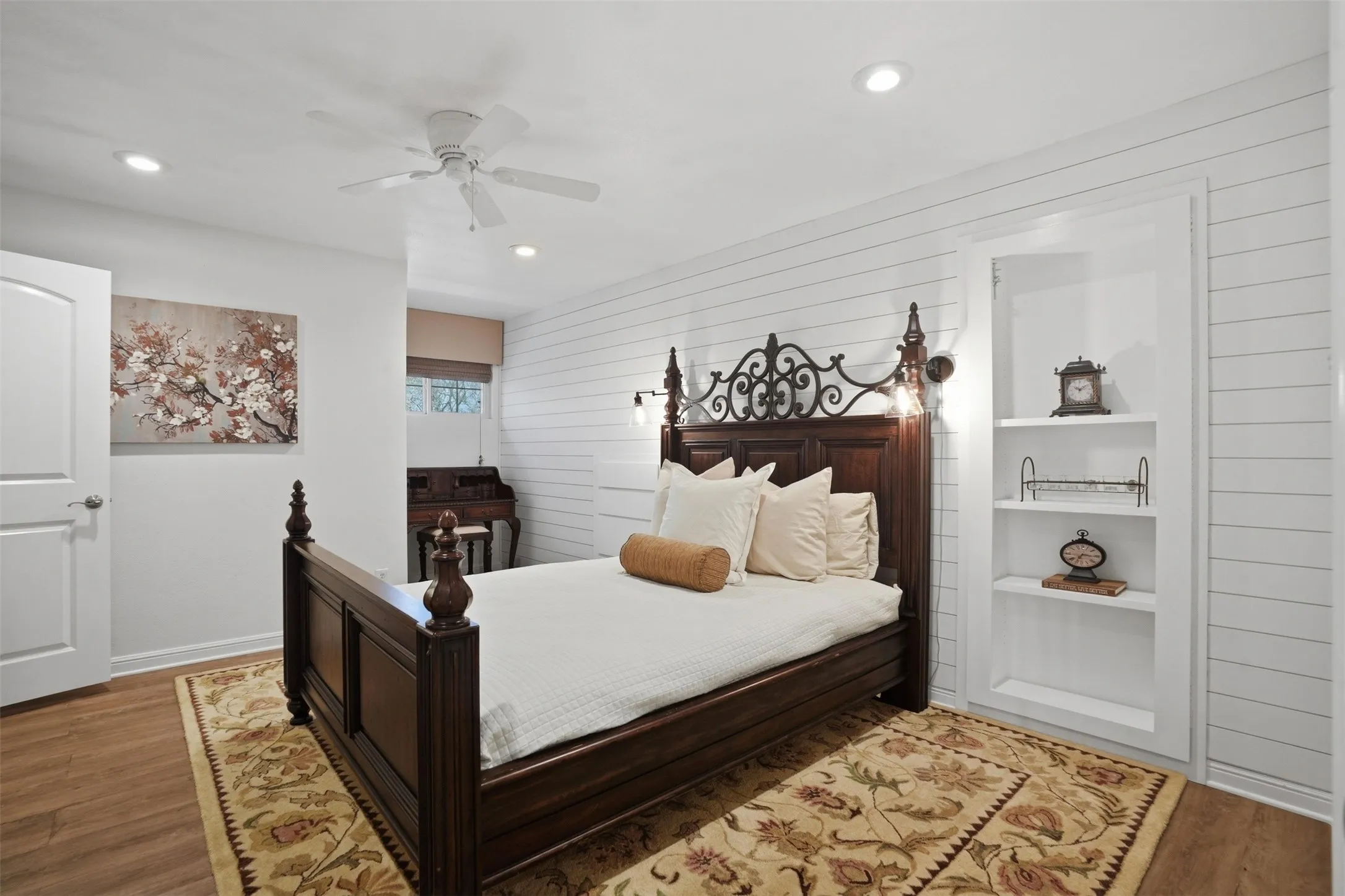 White shiplap accent wall, built-in shelving, wood-finish flooring, recessed lighting, and a ceiling fan