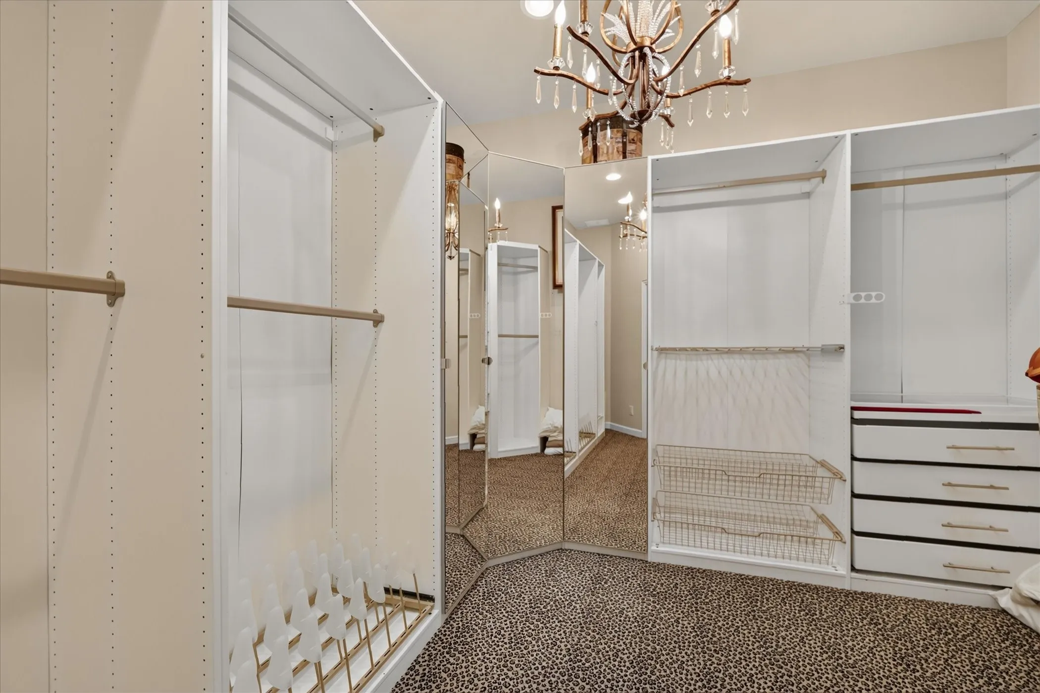 Built-in closet organization system featuring adjustable shelving, integrated drawers, wire baskets, and multiple hanging rods