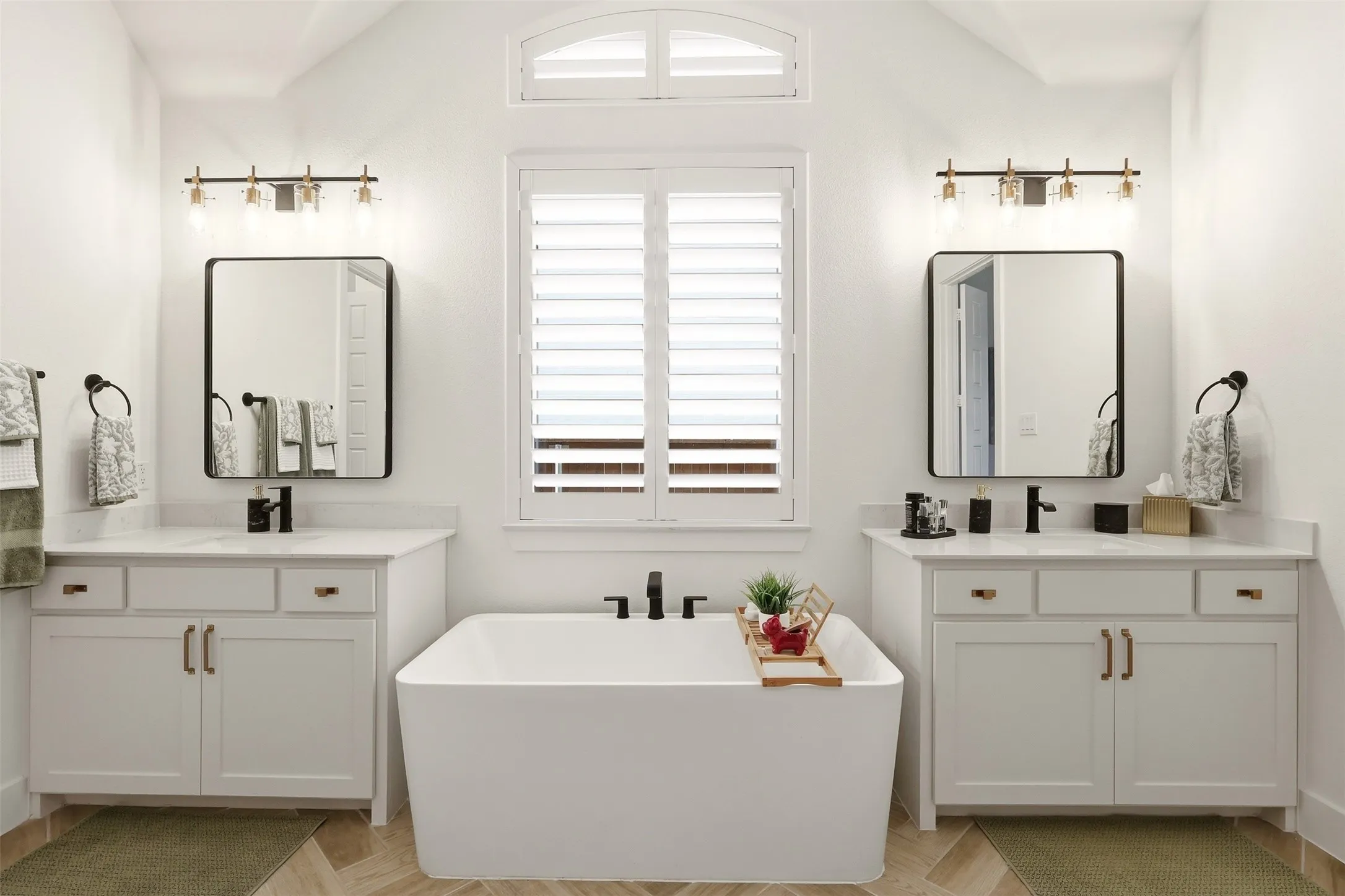 Separate bathroom vanities with soaking tub